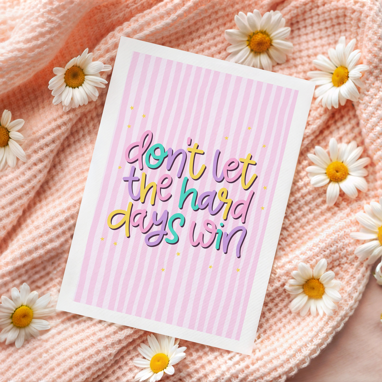 a greeting card, with a pink striped background, and colourful text reading 'Don't let the hard days win'