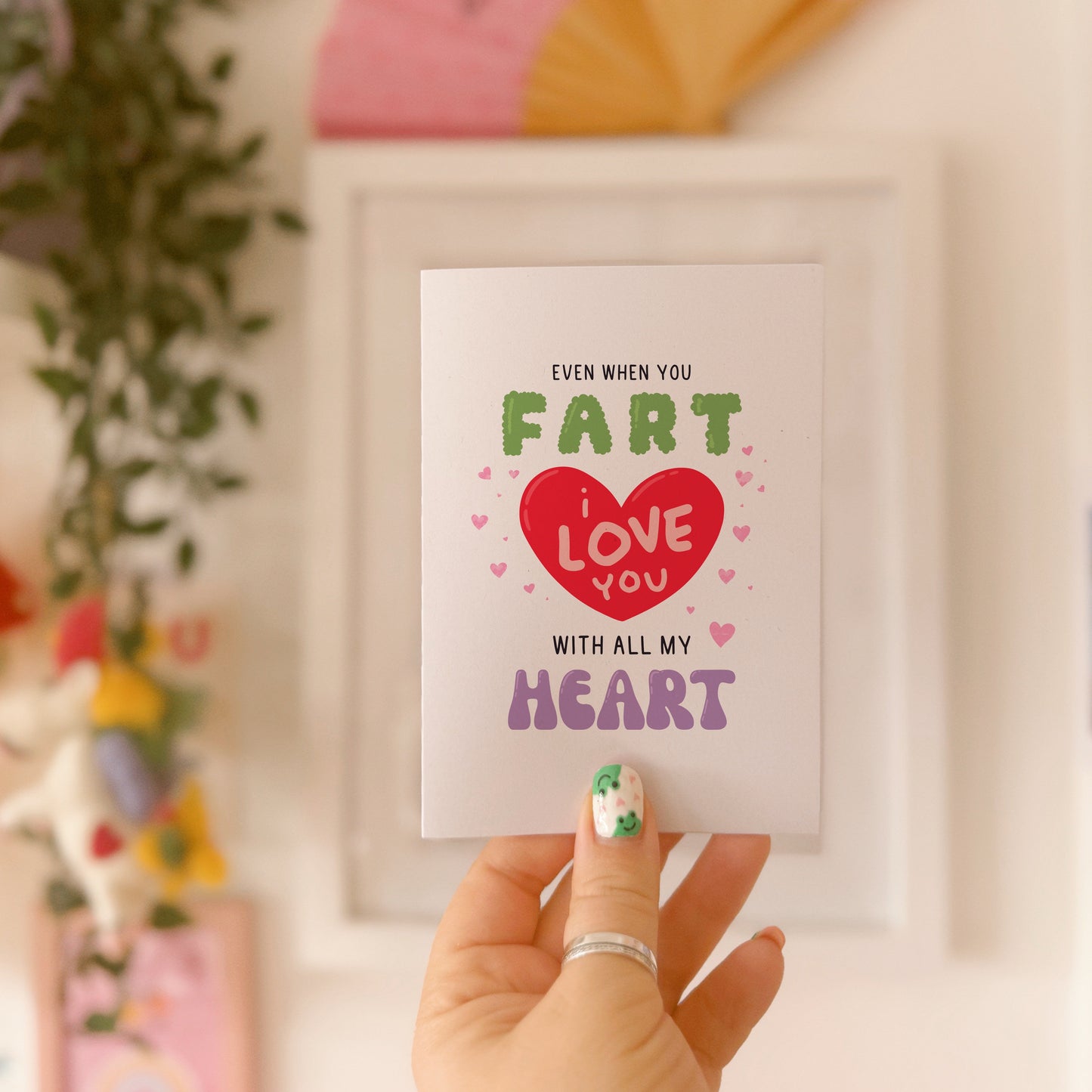 A funny quote love themed card, that says 'even when you fart, I love you with all my heart, in hand drawn lettering.