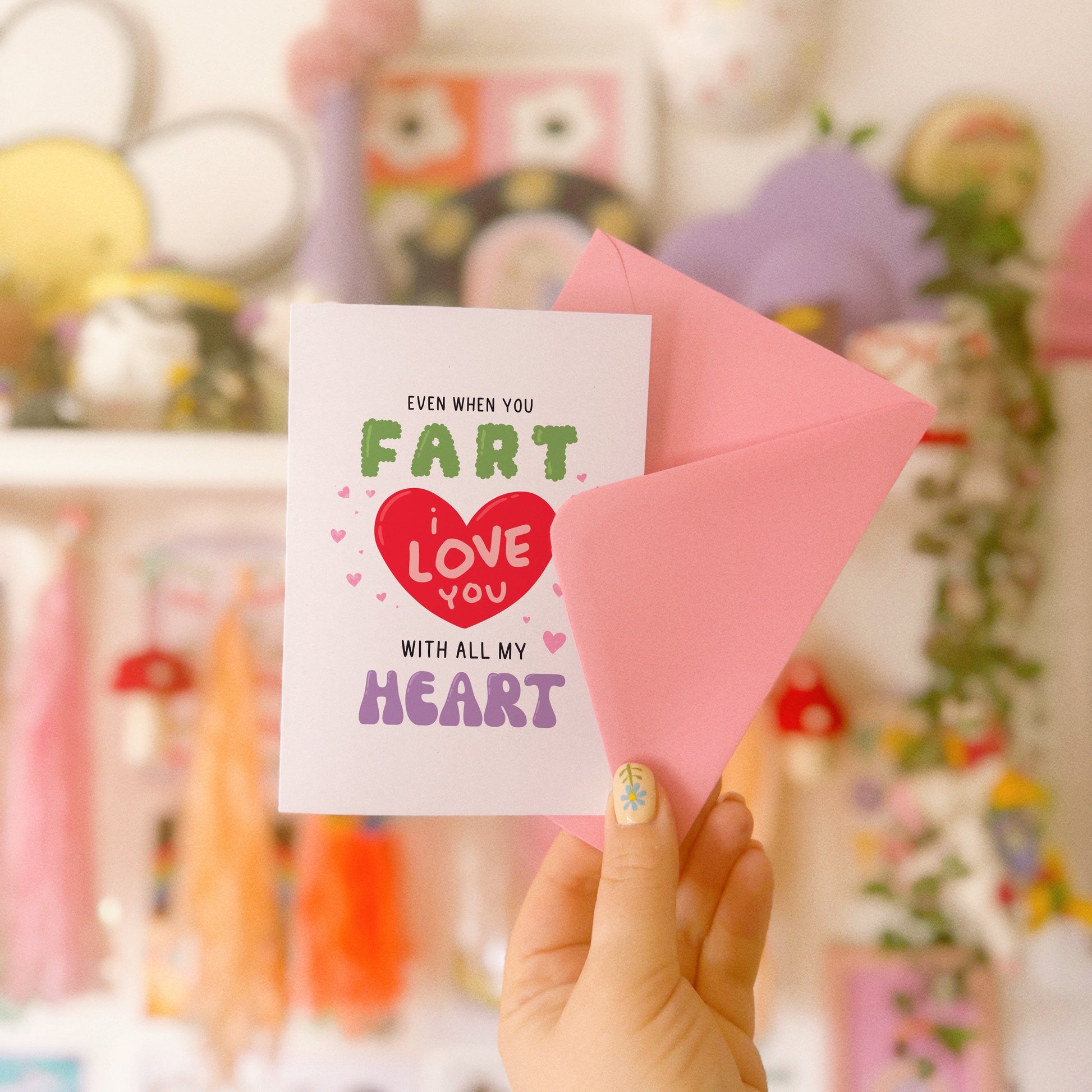 A funny quote love themed card, that says 'even when you fart, I love you with all my heart, in hand drawn lettering.