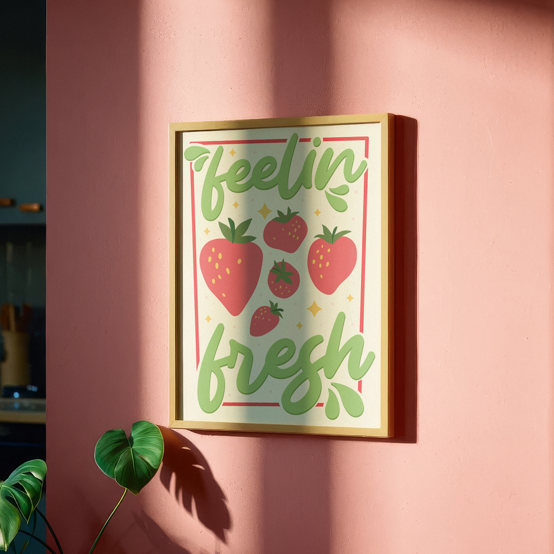 A colourful art print with the phrase 'feelin' fresh' surrounded by illustrations of strawberries, shown in a frame.