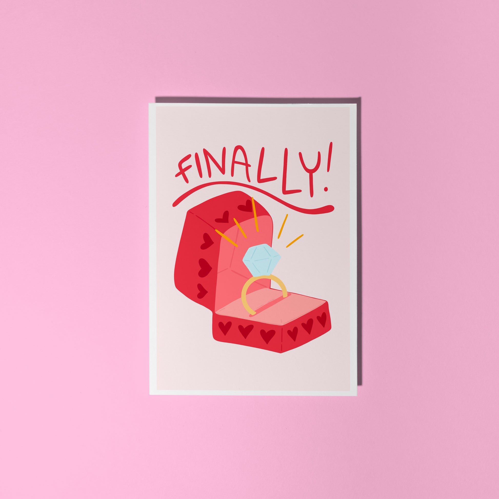 Card with a red engagement ring box and the word 'FINALLY!' on a light pink background.