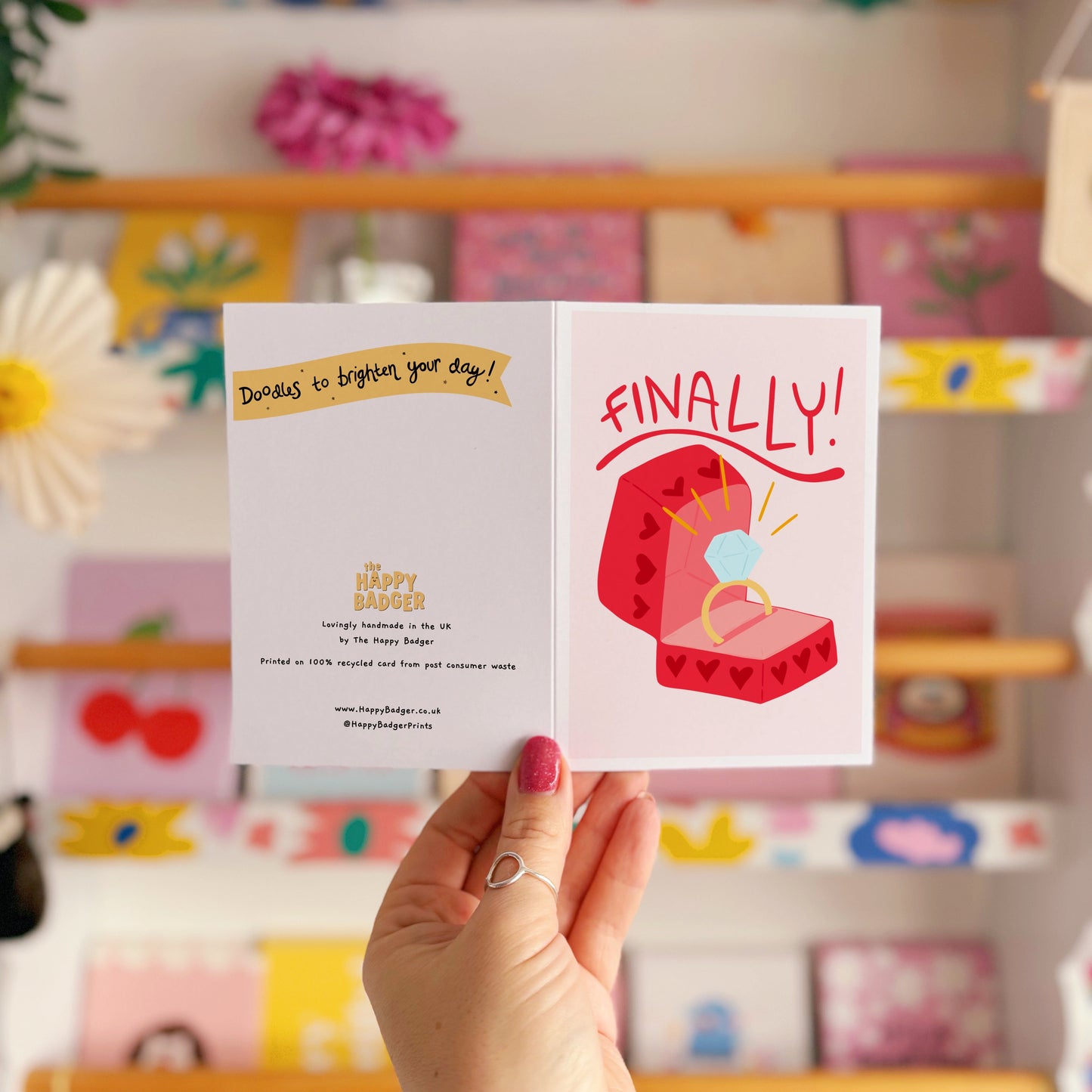 Card with a red engagement ring box and the word 'FINALLY!' on a light pink background.