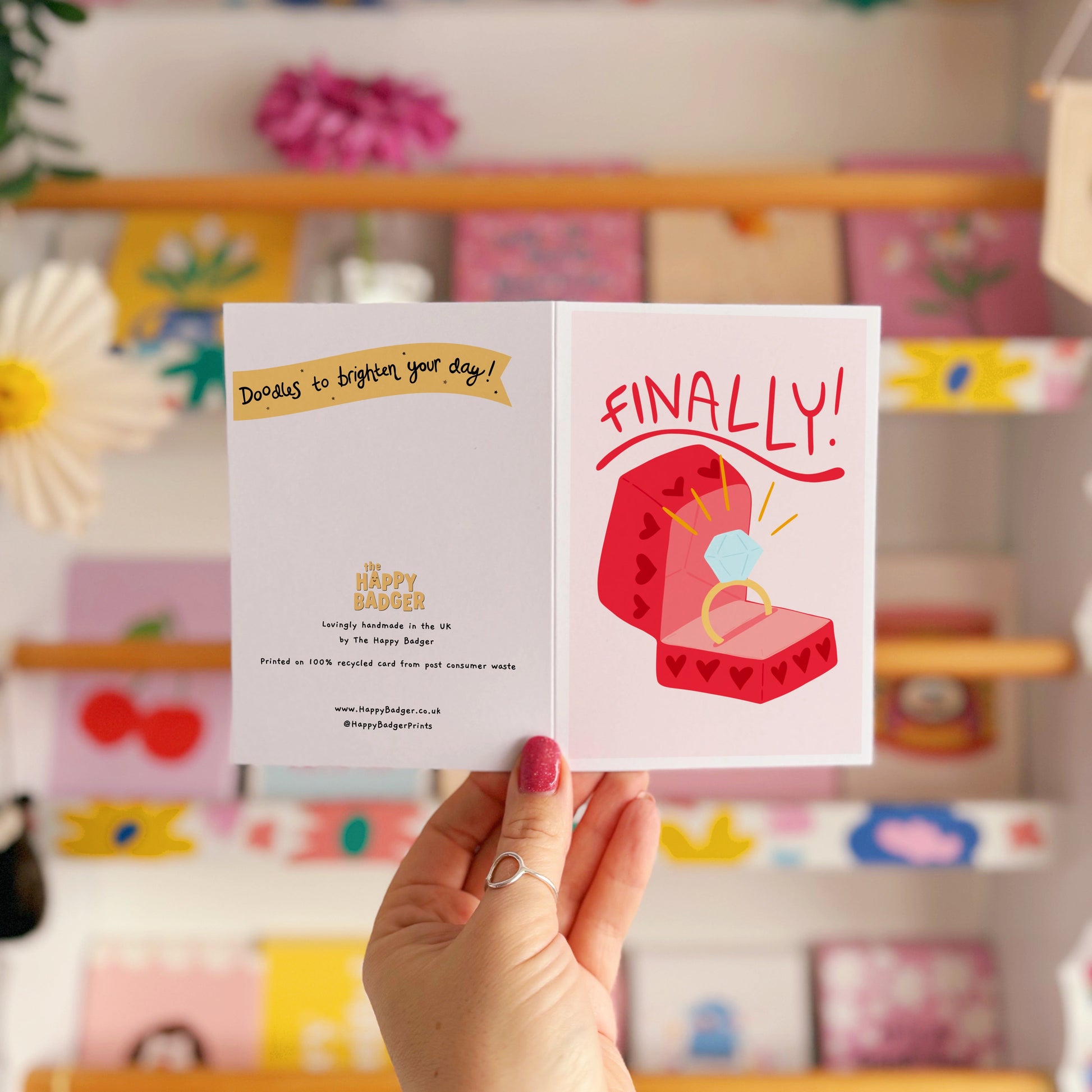 Card with a red engagement ring box and the word 'FINALLY!' on a light pink background.