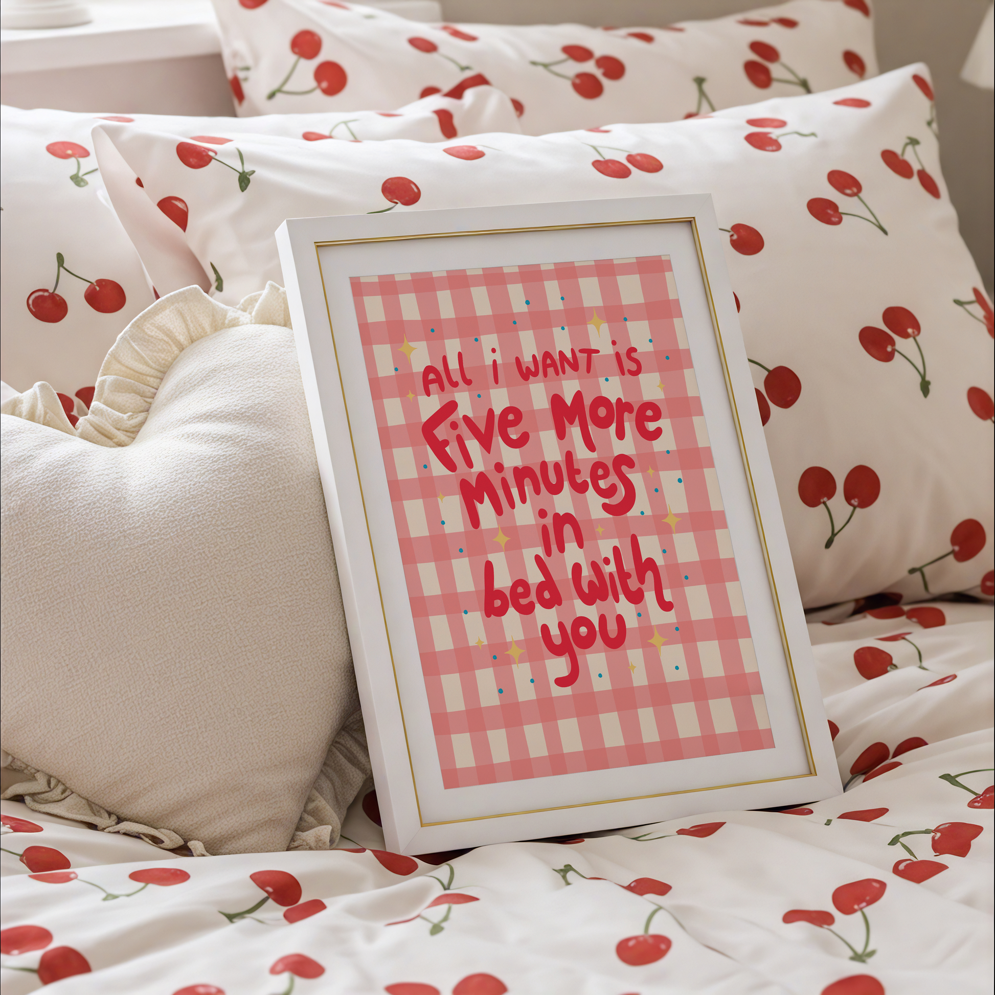 A pinky red checkered print with hand lettered text that says 'all I want is five more minutes in bed with you'.