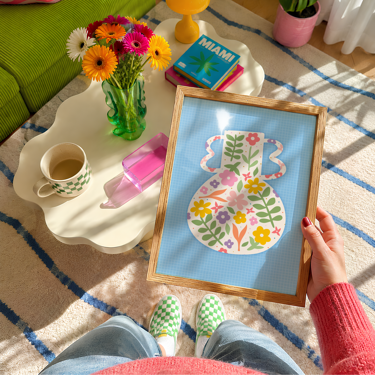 A blue art print featuring a vibrant vase illustration with floral patterns against a blue textured background.