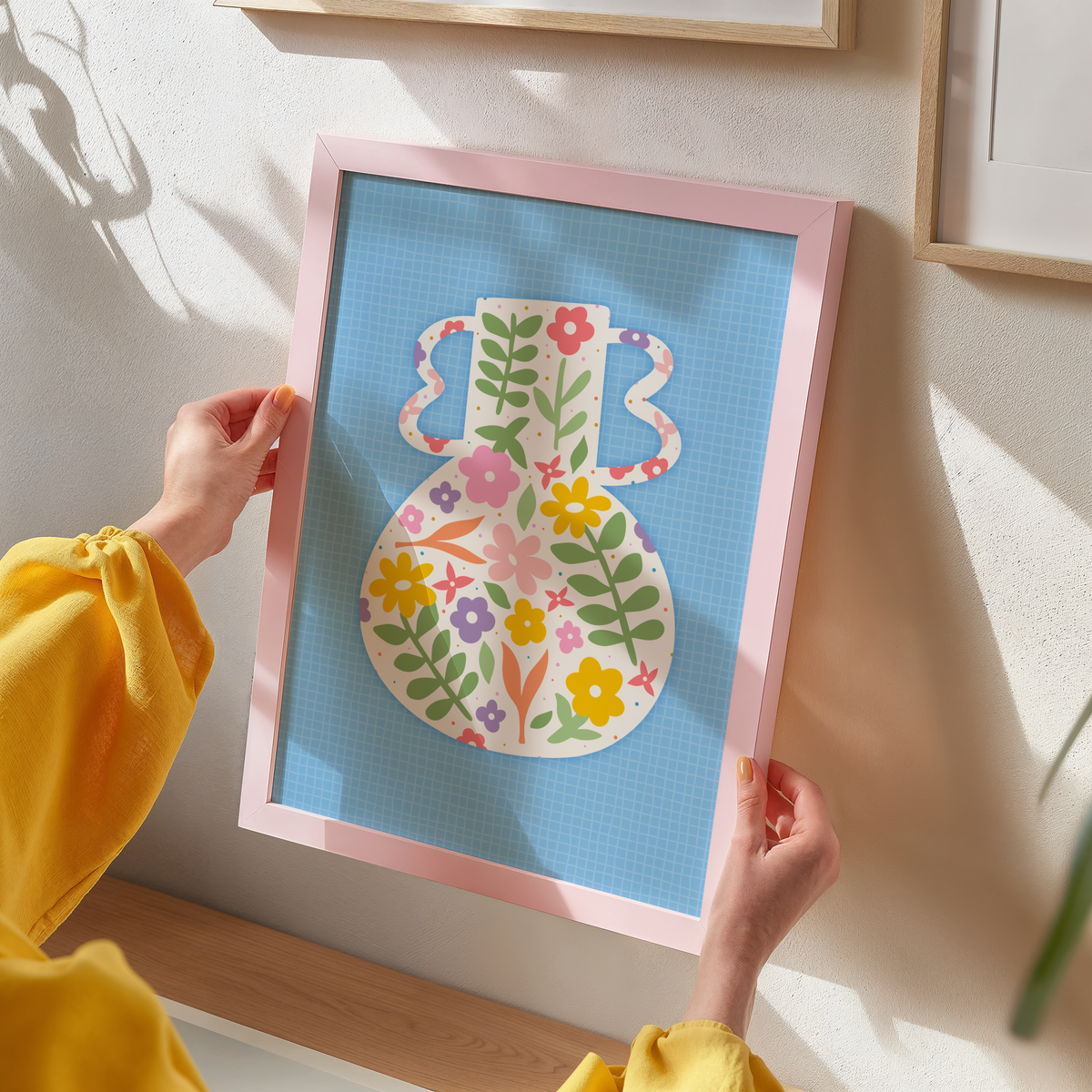 A blue art print featuring a vibrant vase illustration with floral patterns against a blue textured background.