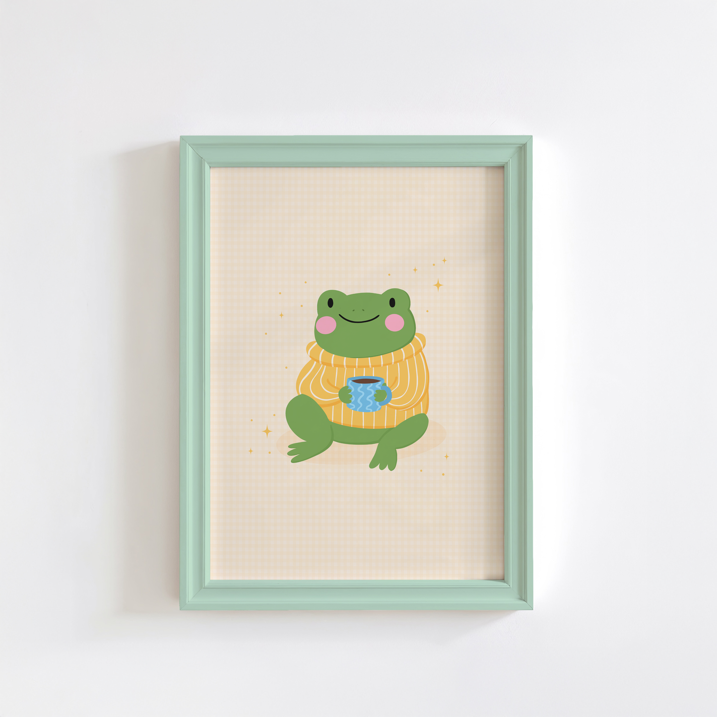 Framed artwork of a frog wearing a sweater with a cup on a pale yellow gingham background.