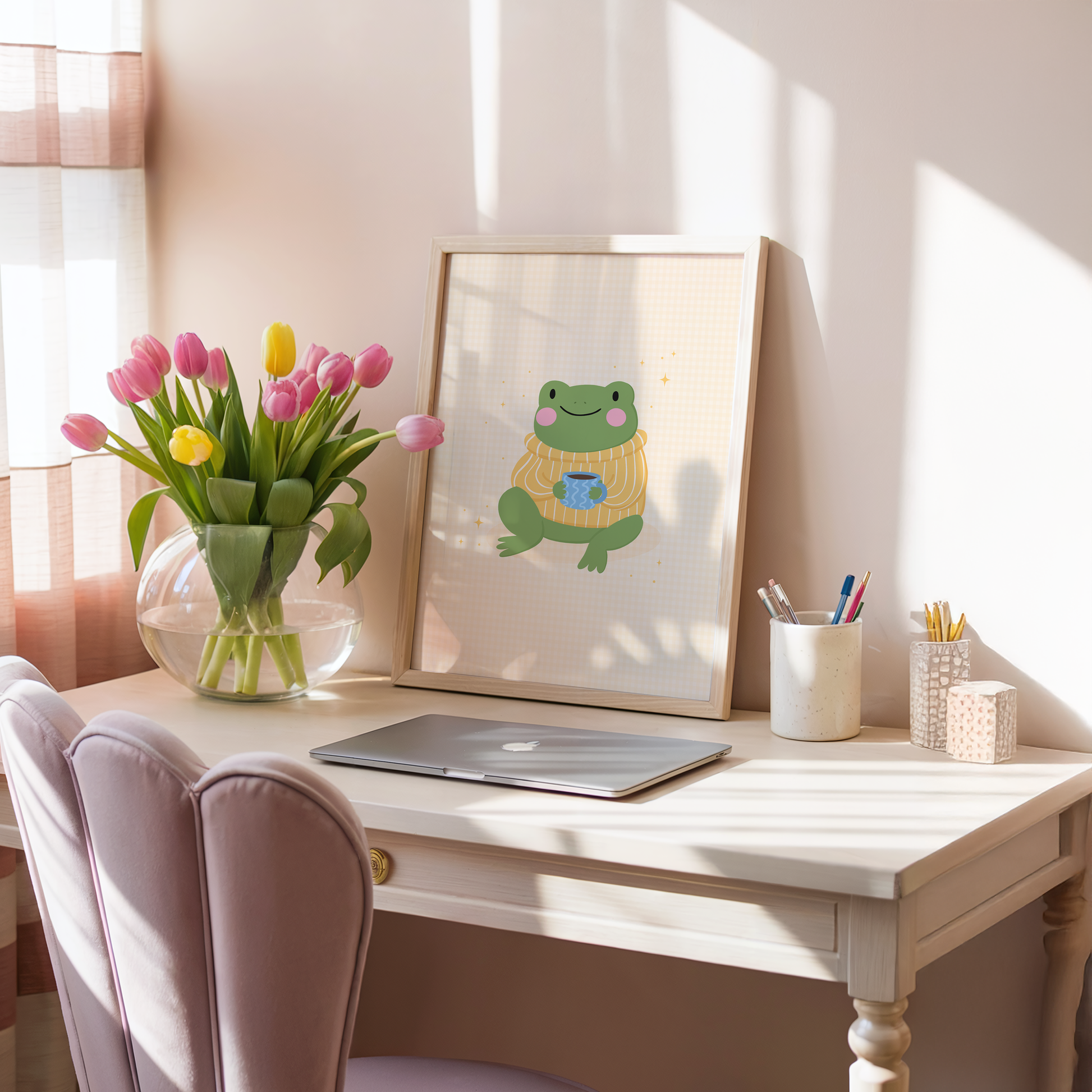 Framed artwork of a frog wearing a sweater with a cup on a pale yellow gingham background.