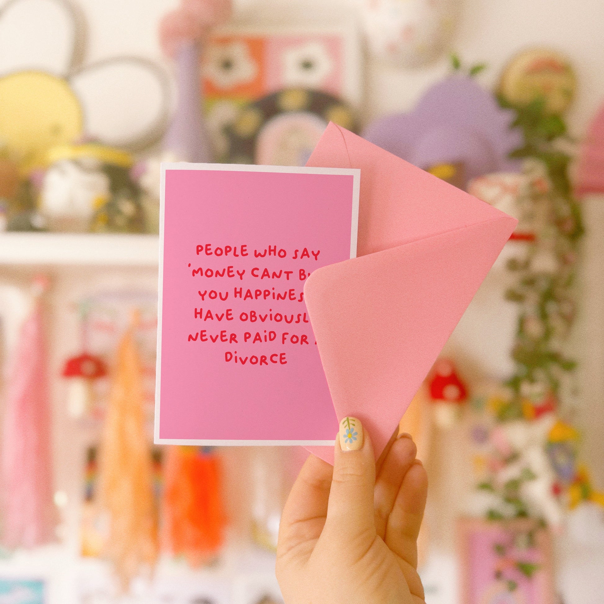 A pink card with a funny quote about celebrating getting divorced.
