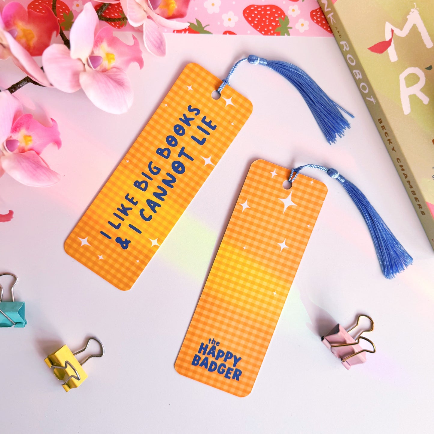 A yellow gingham bookmark with a blue tassel, and blue text that reads 'I like big books and I cannot lie' on the front side.