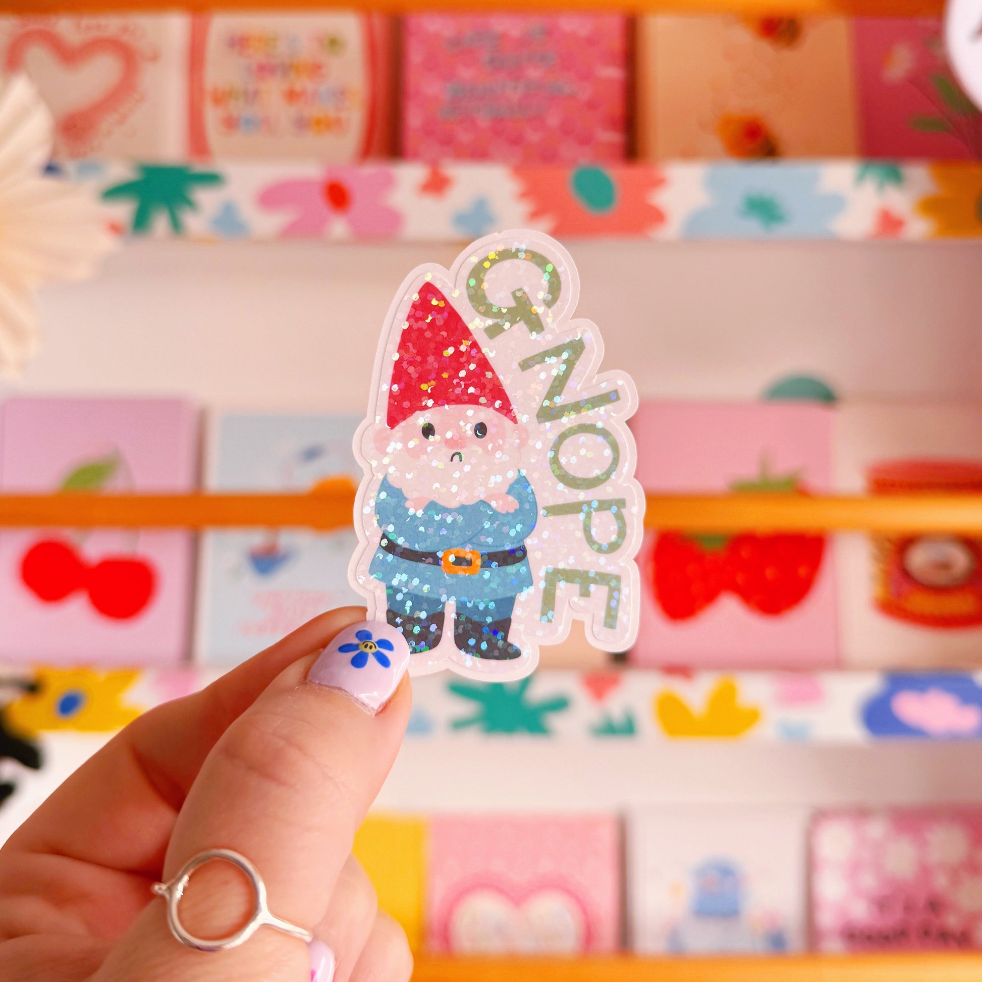 A holographic sticker of a grumpy garden gnome, and the word 'gnope' next to him.