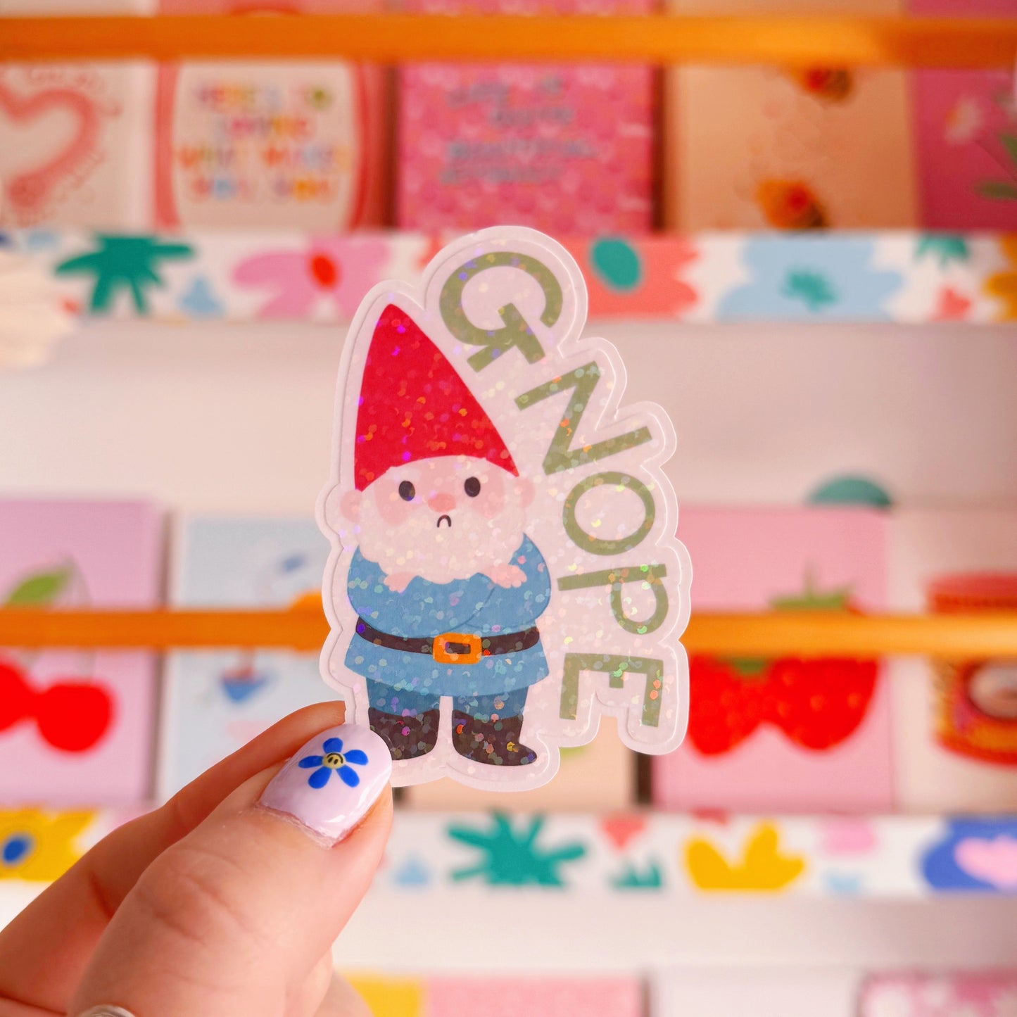 A holographic sticker of a grumpy garden gnome, and the word 'gnope' next to him.