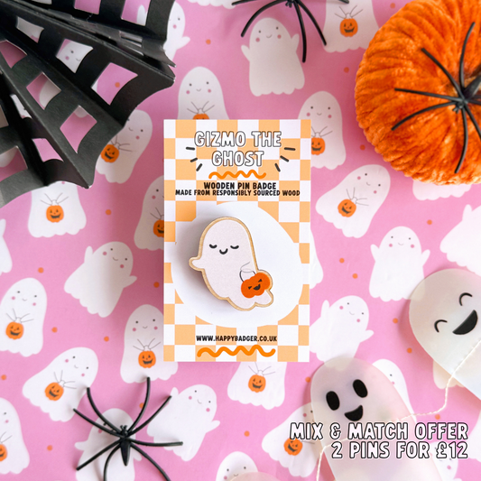 A wooden pin badge, of a cute smiling ghost, holding a trick or treating tub which is a pumpkin.