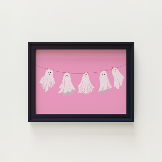 A pink Halloween print with five different ghosts made from bedsheets, hanging on a washing line.