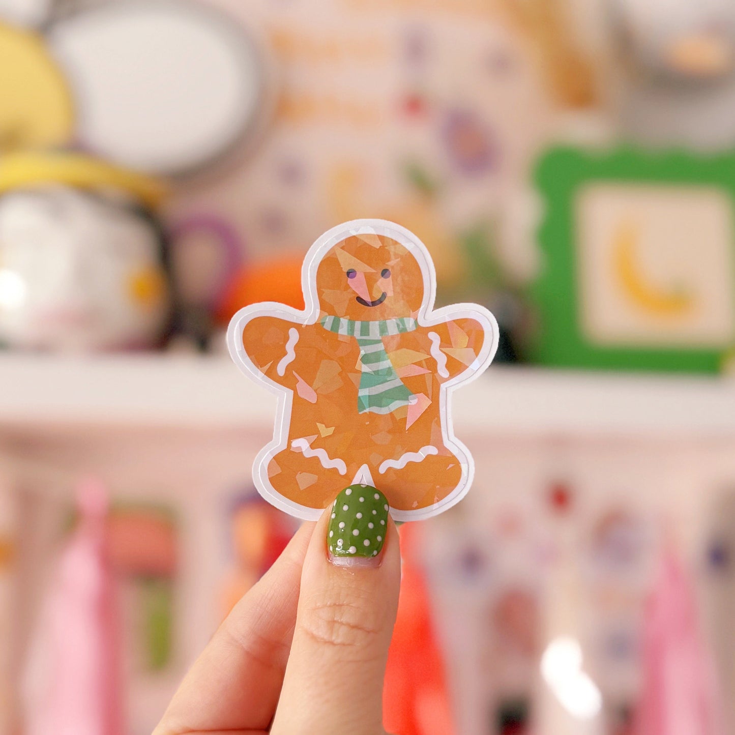 Hand holding a gingerbread man sticker with a blurred background