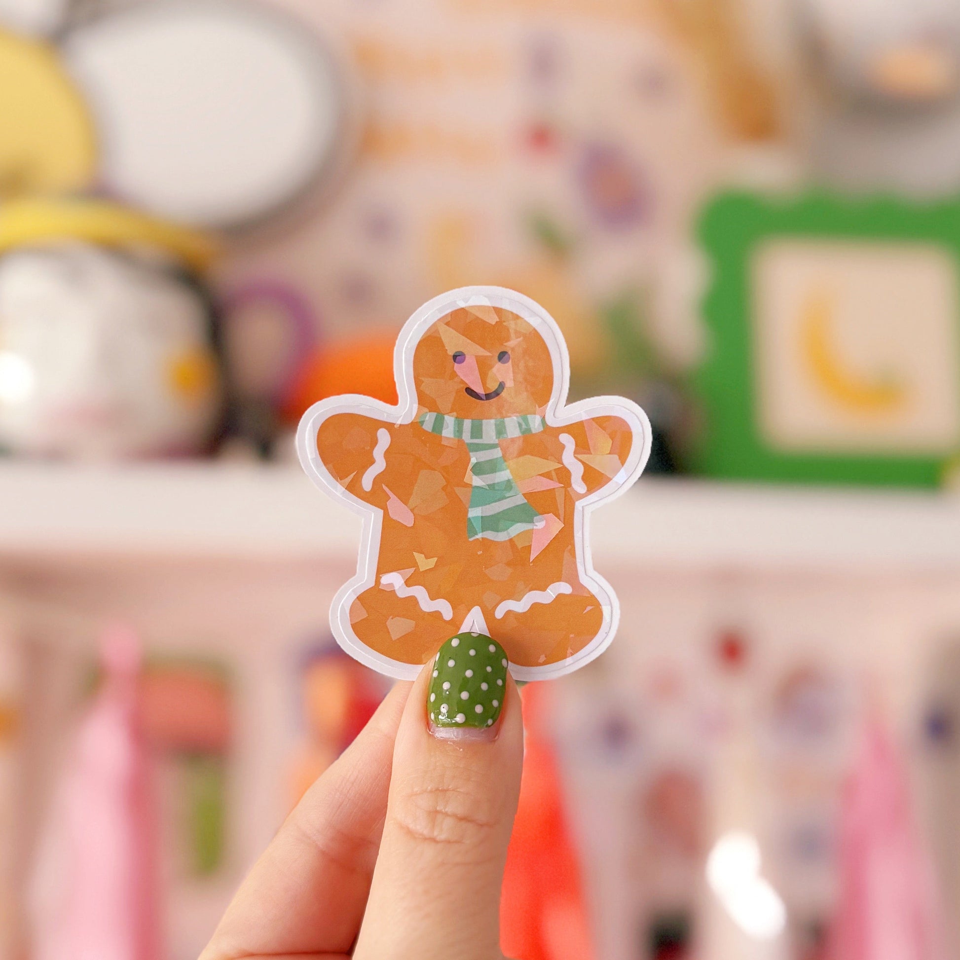 Hand holding a gingerbread man sticker with a blurred background