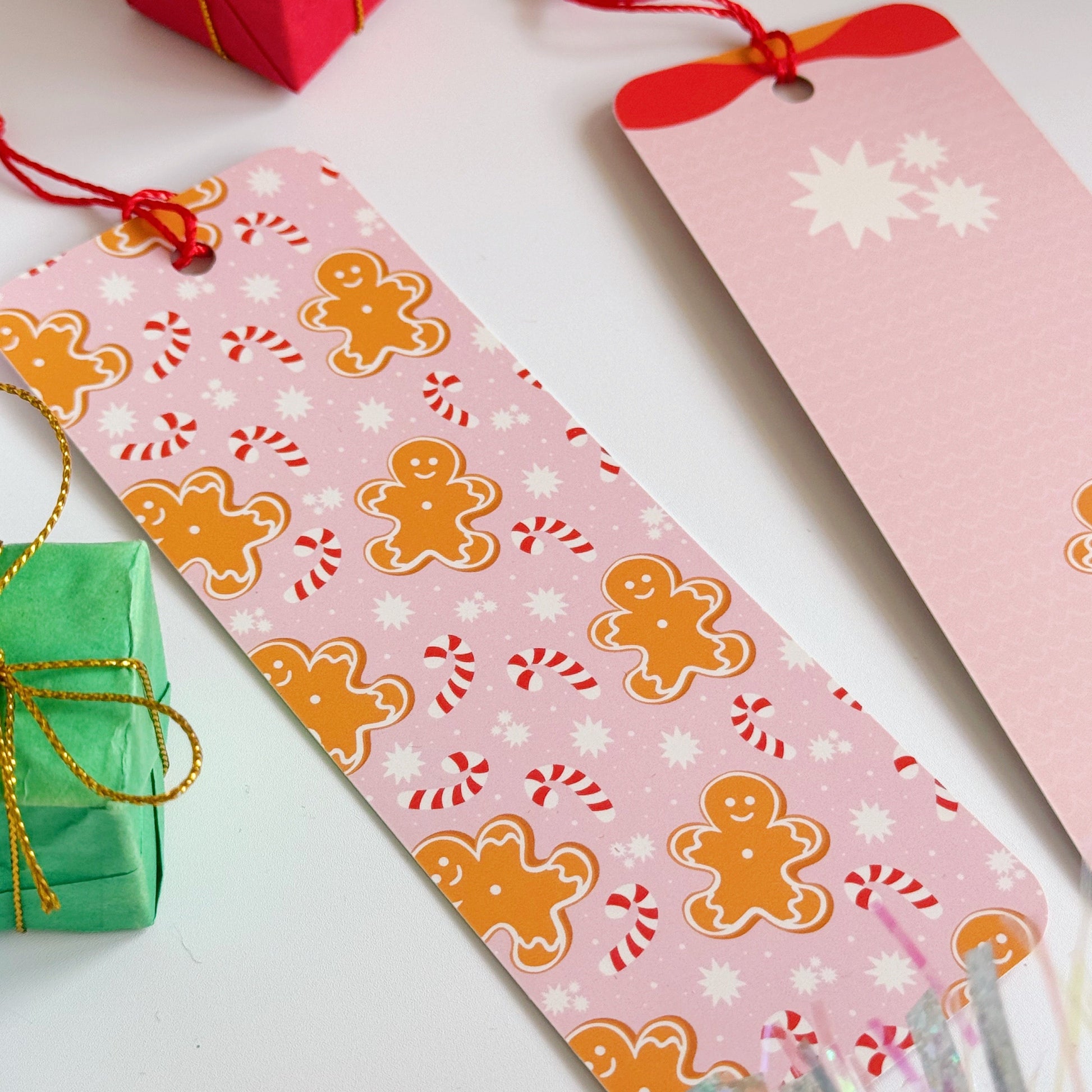 Festive bookmark with gingerbread men and candy cane patterns on a white surface with gift boxes.
