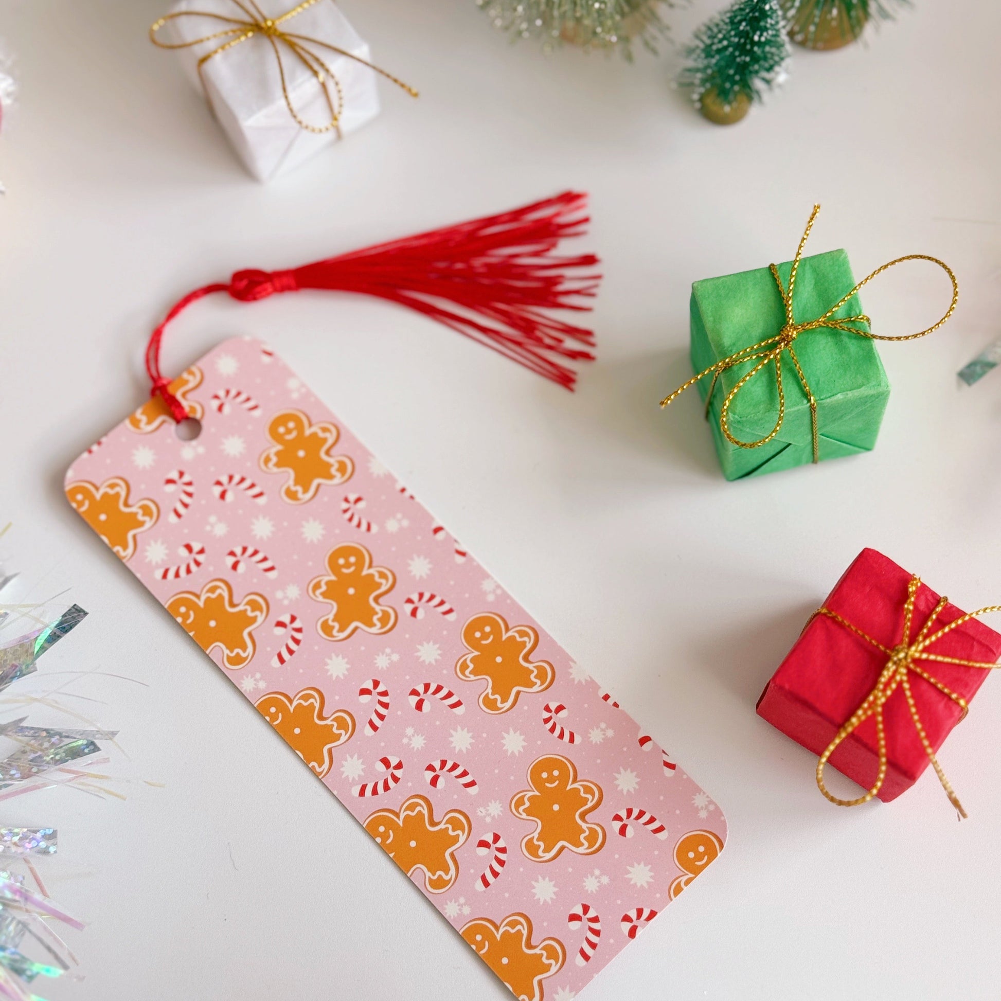 Decorative bookmark with gingerbread design on a white surface with Christmas decorations.
