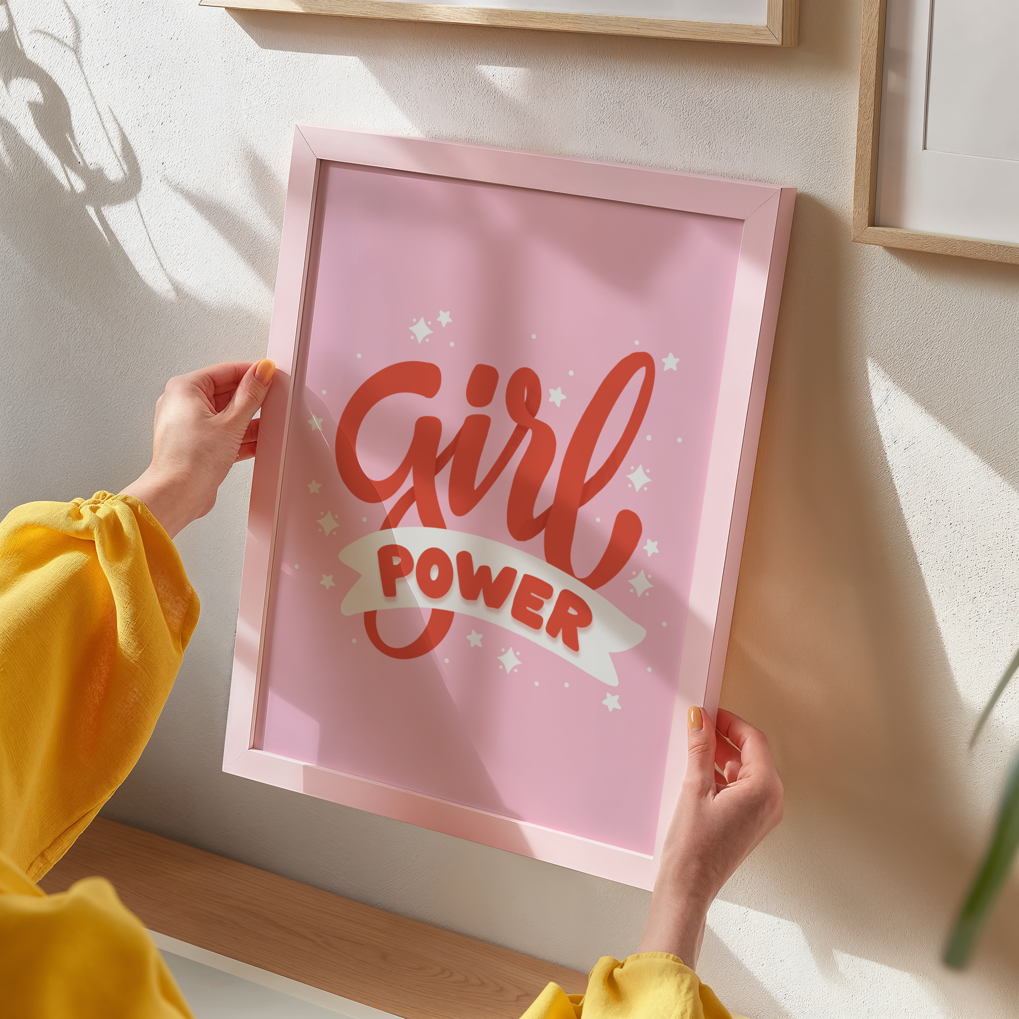 A quote print with the words 'Girl Power' in red text on a pink background.