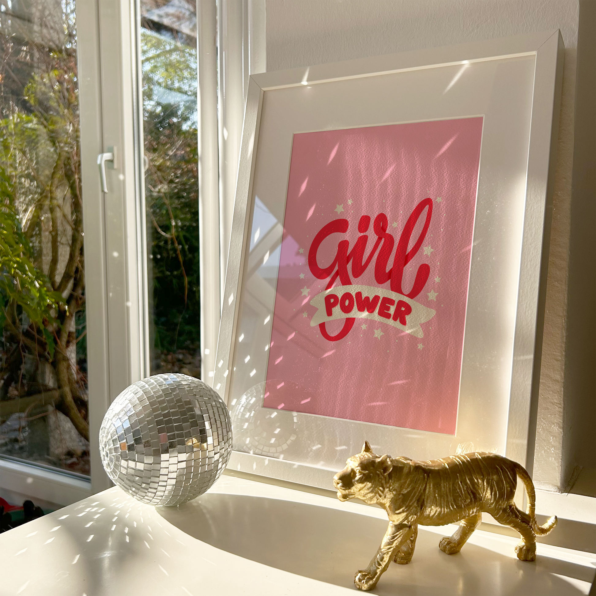 A pink print with red lettering that reads 'Girl power', decorated with little white stars.