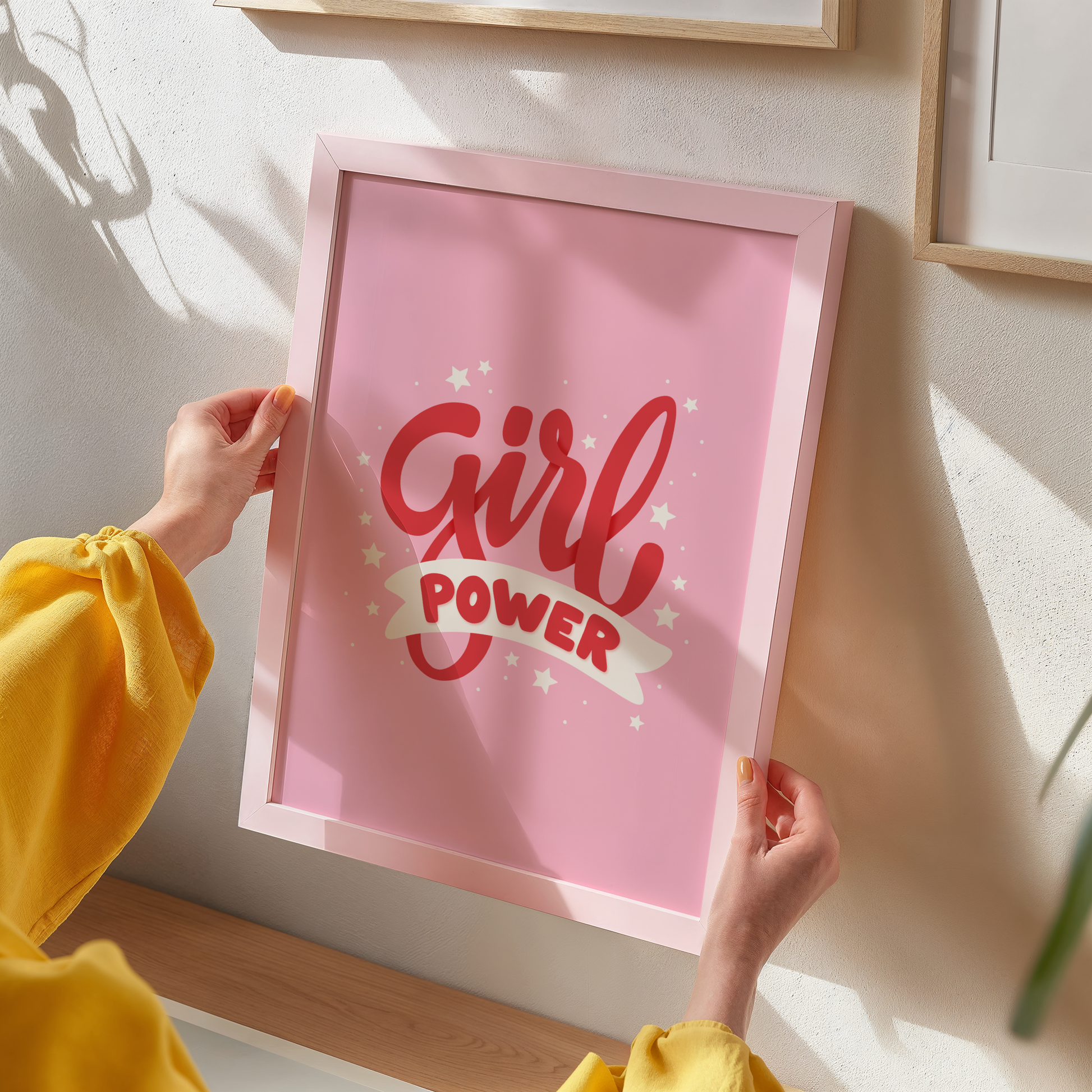 A pink print with red lettering that reads 'Girl power', decorated with little white stars.