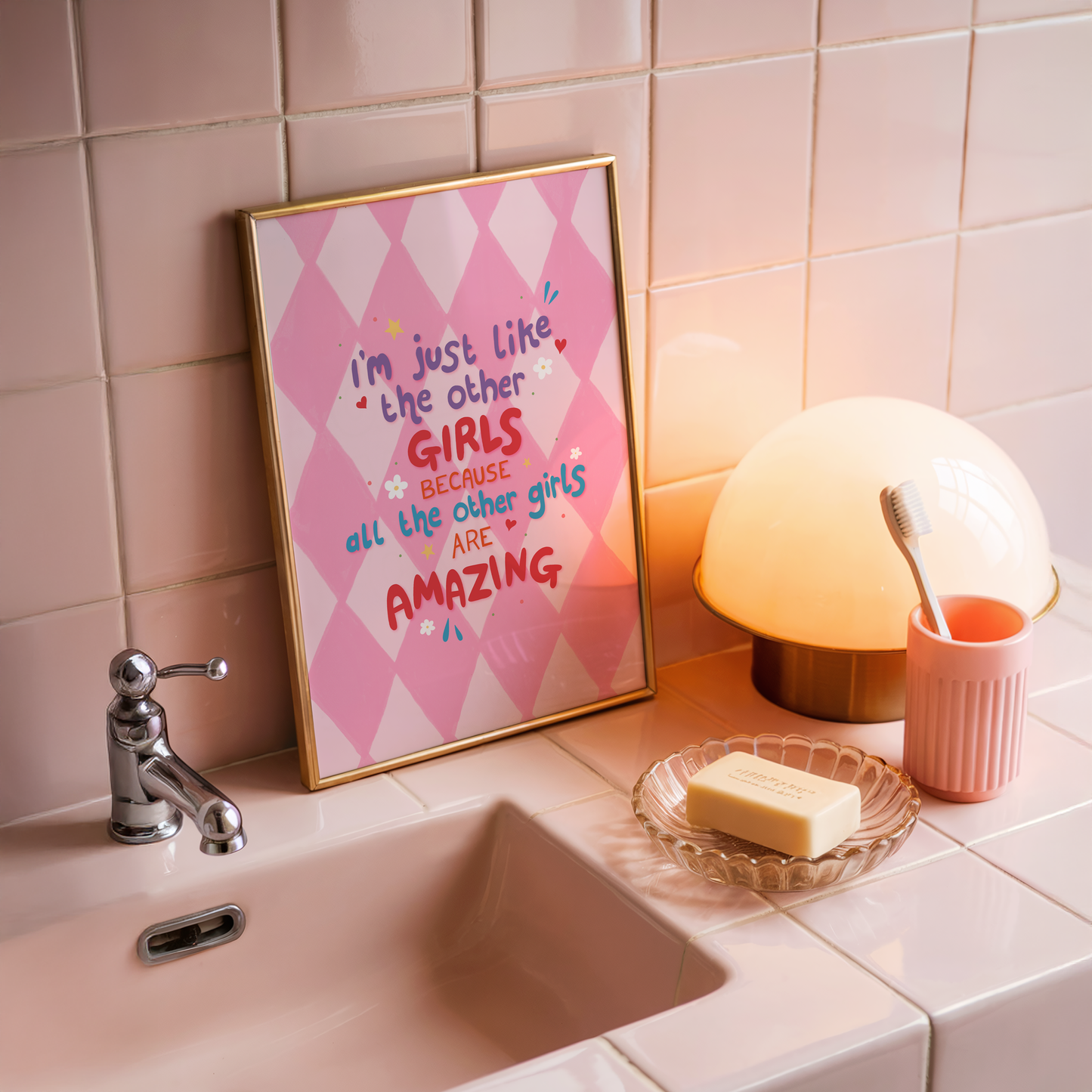 A pink harlequin patterned background with a female empowerment quote print in different coloured hand lettered text.