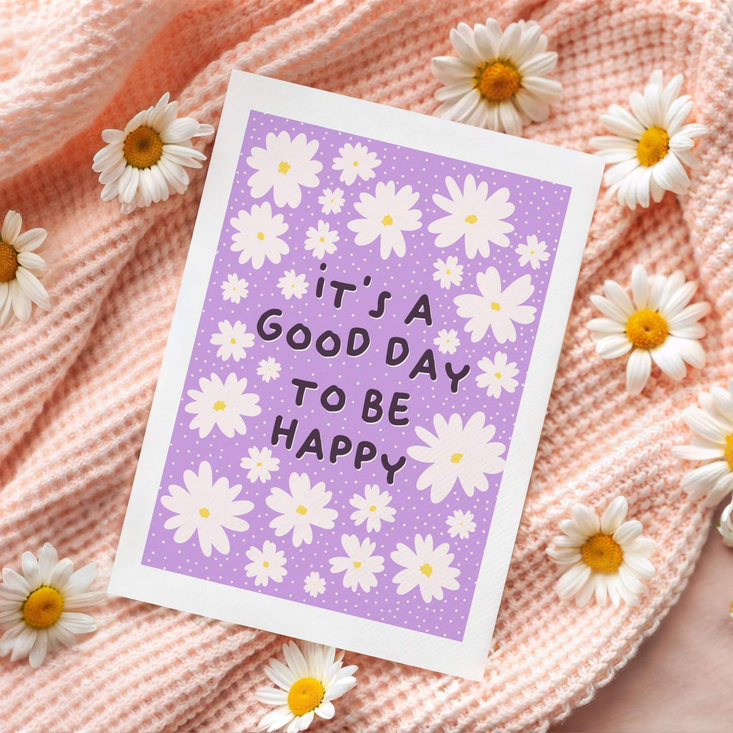 A purple card, with daisies, and the message 'it's a good day to be happy' in the centre. 