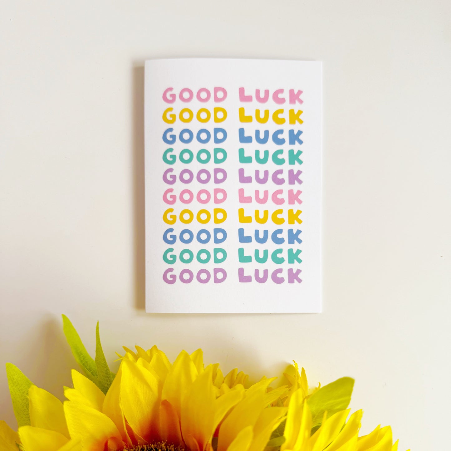 A greetings card, with the phrase 'good luck' repeated several times in colourful shades.