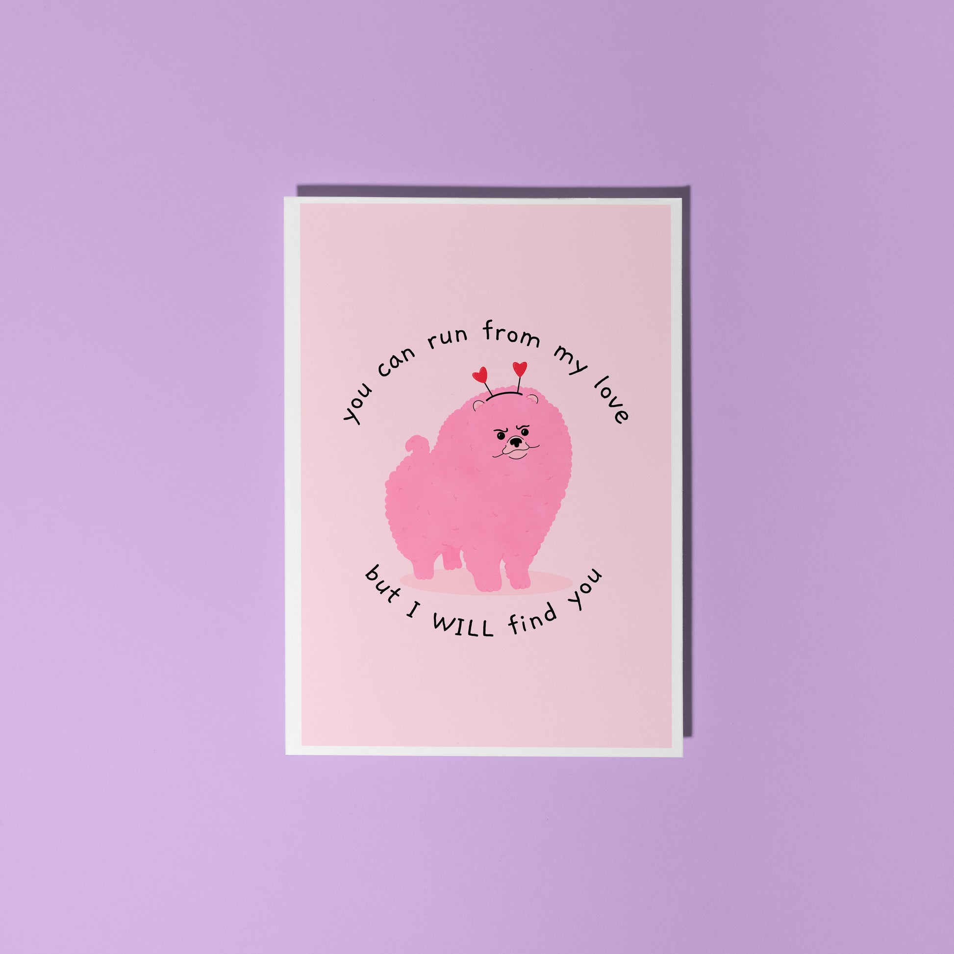 A pink love themed card with an illustration of a pink grumpy dog on the front and text that reads 'you can run from my love, but I WILL find you'.