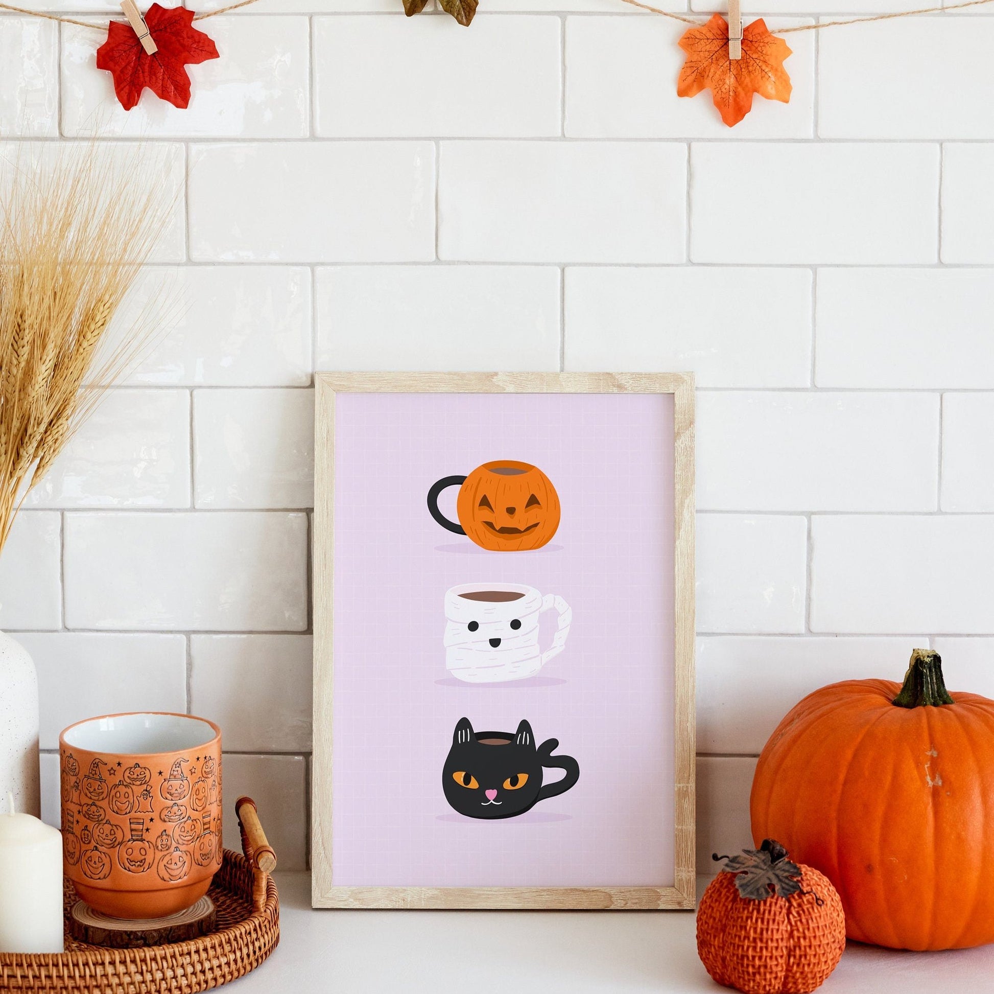 A halloween themed print, featuring three mugs - a pumpkin mug, a mummy mug and a black cat mug.