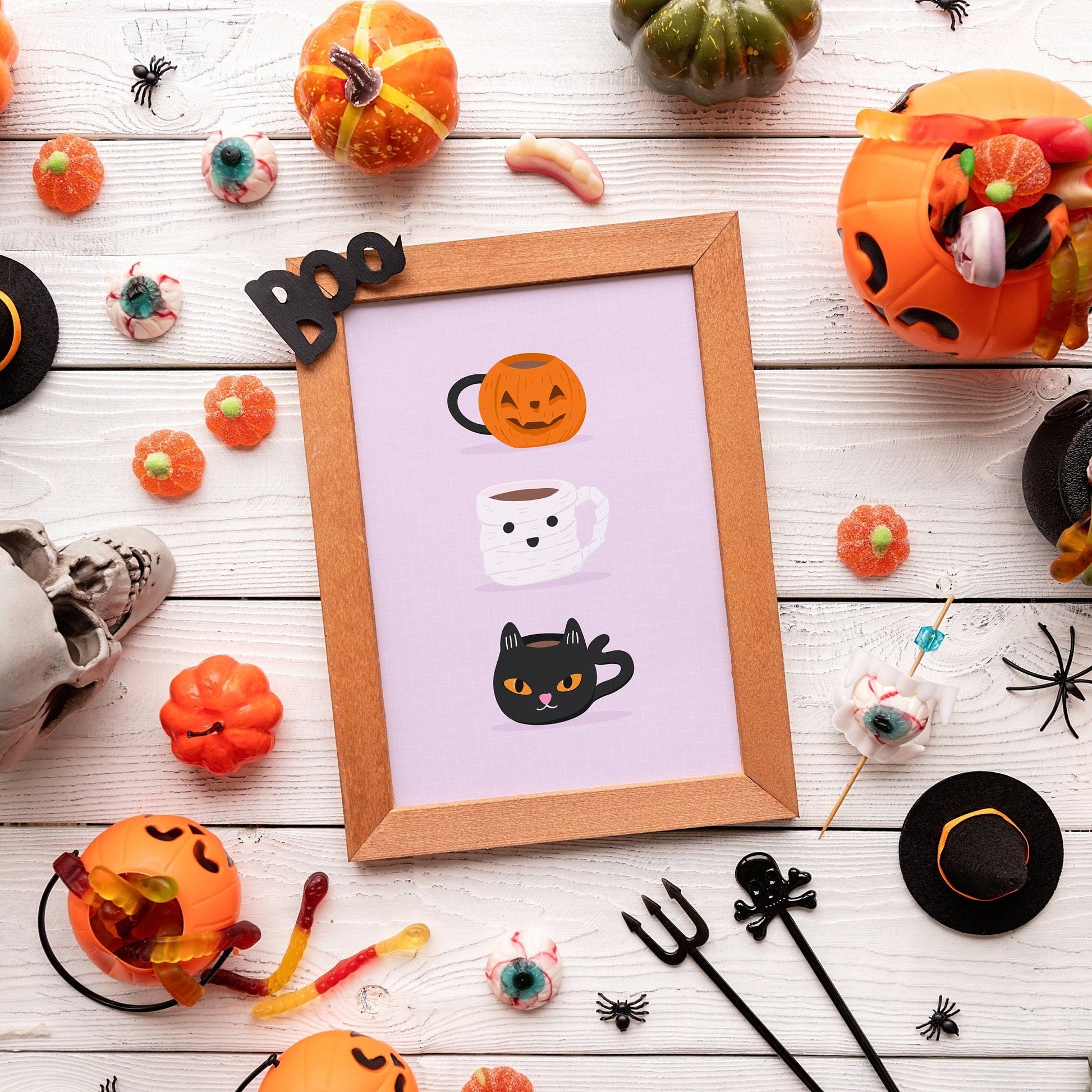 A halloween themed print, featuring three mugs - a pumpkin mug, a mummy mug and a black cat mug.