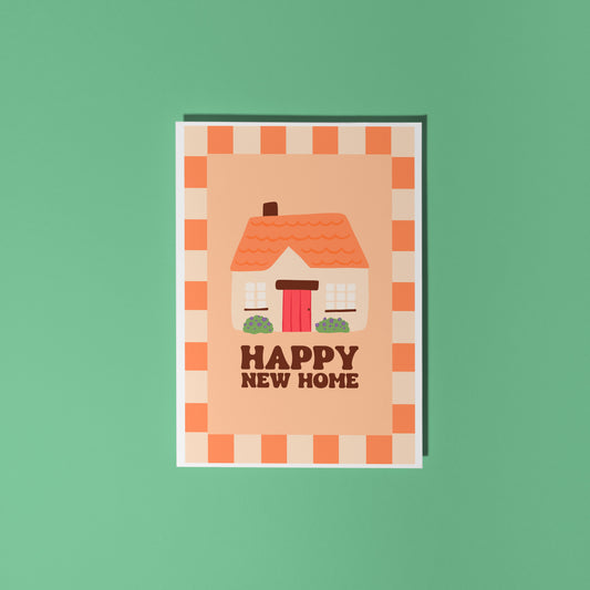 An orange card, with an illustration of a cute cottage on the front and the words 'happy new home' underneath.