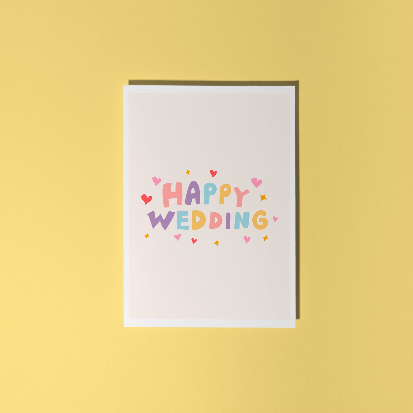 A minimalistic card with colourful hand lettering that reads 'Happy Wedding' with little heart and star doodles around it.