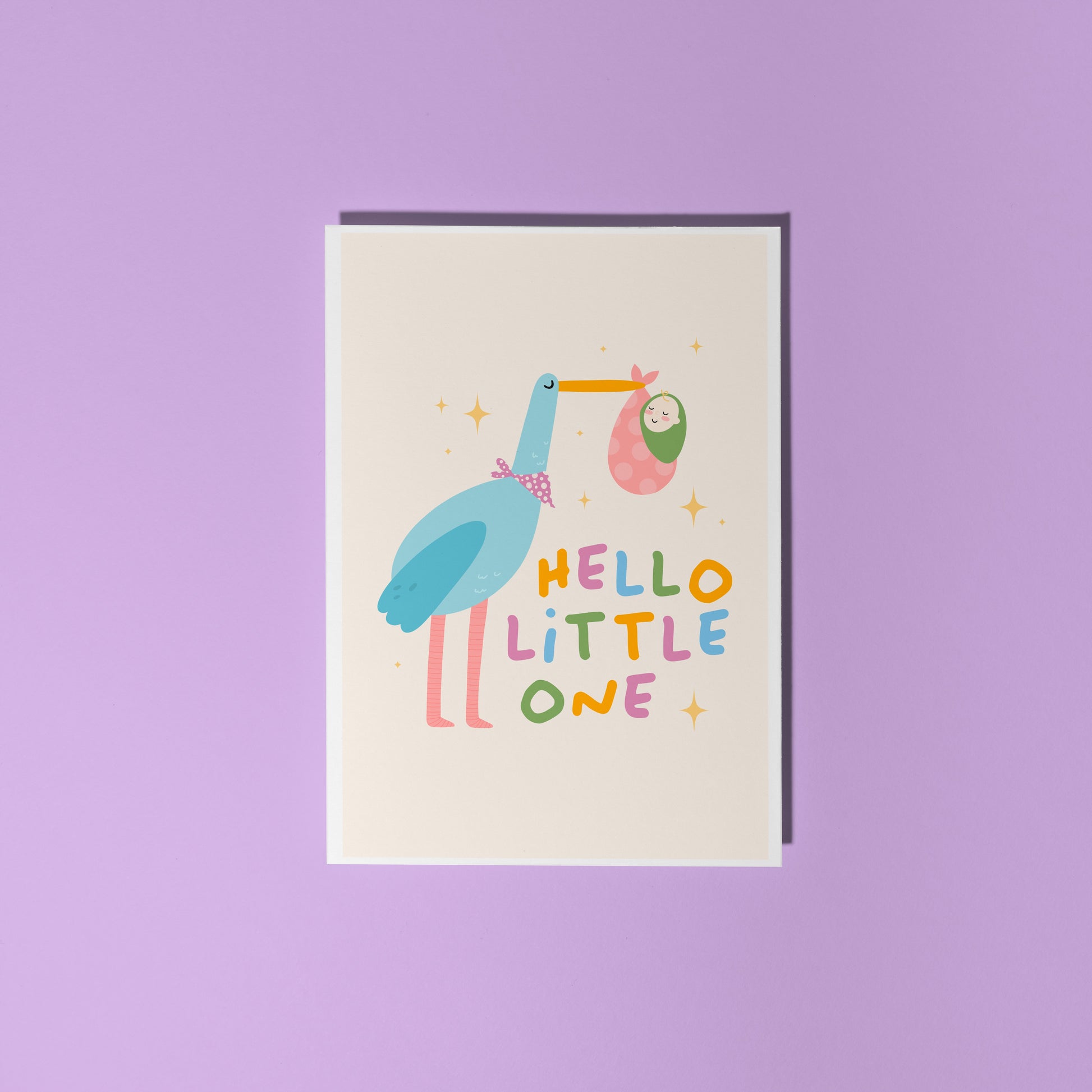 A greetings card with an illustration of a stalk carrying a baby, with the words 'hello little one' in colourful tones.
