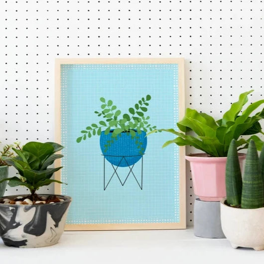 An illustration of a house plant in a blue plant pot, on a light blue textured background.