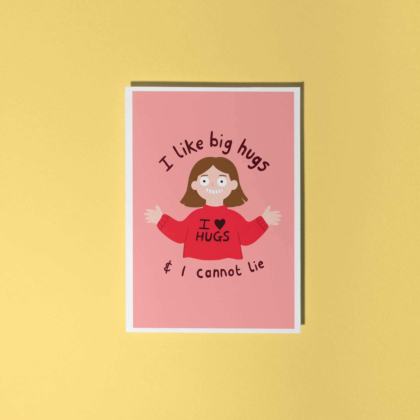 A pinkish red card with an illustration of a slightly creepy looking woman wearing a red jumper that says 'I love hugs' and text around her saying 'I like big hugs and I cannot lie'.