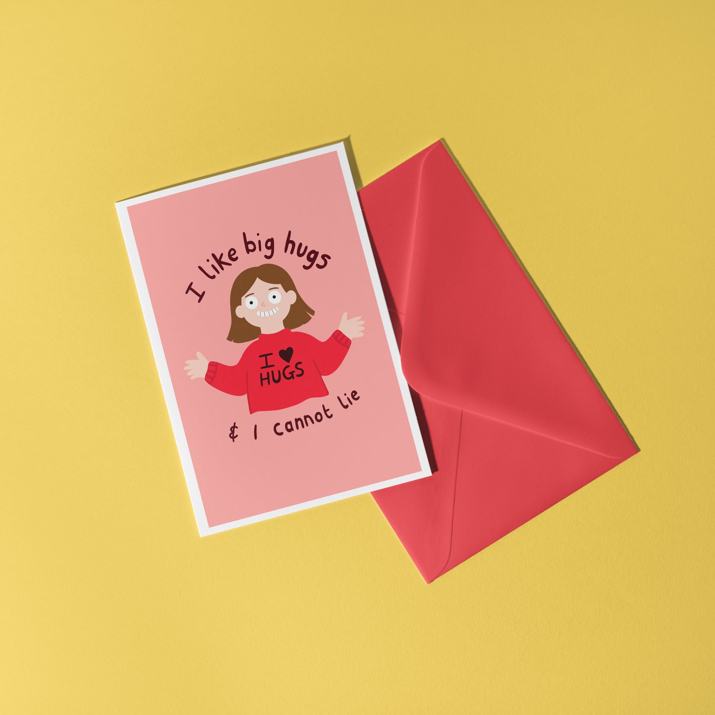 A pinkish red card with an illustration of a slightly creepy looking woman wearing a red jumper that says 'I love hugs' and text around her saying 'I like big hugs and I cannot lie'.
