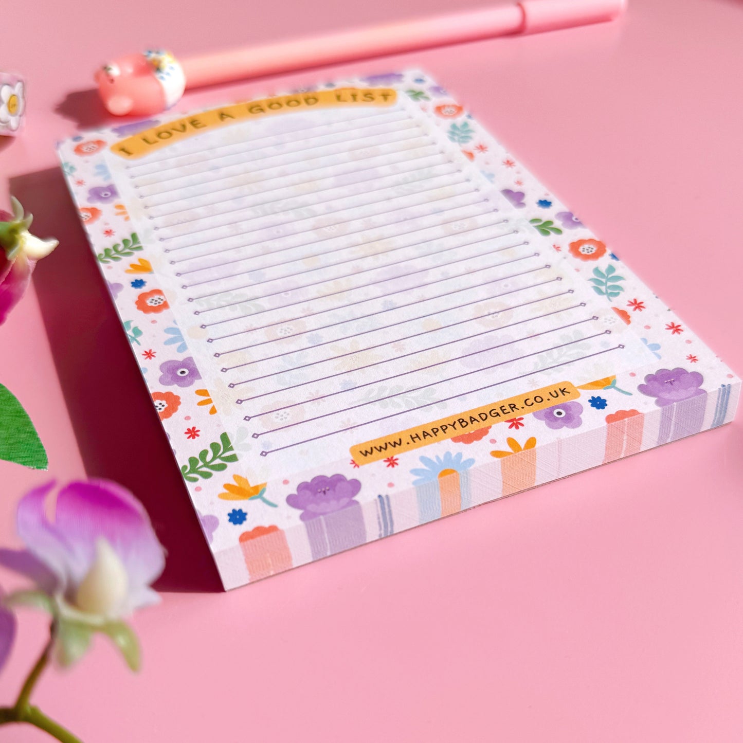 Colorful notepad with floral design on a pink background