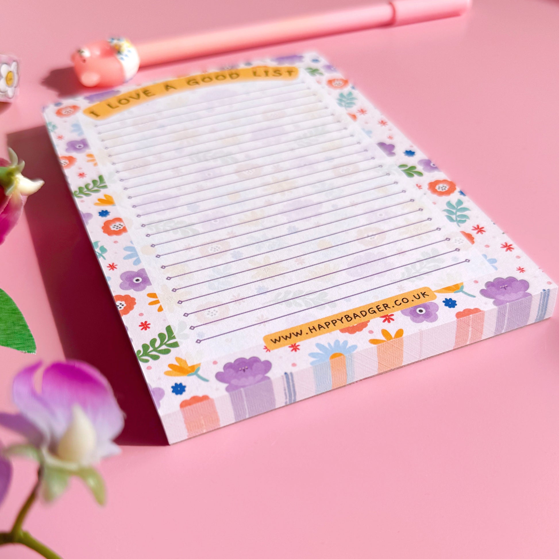 Colorful notepad with floral design on a pink background