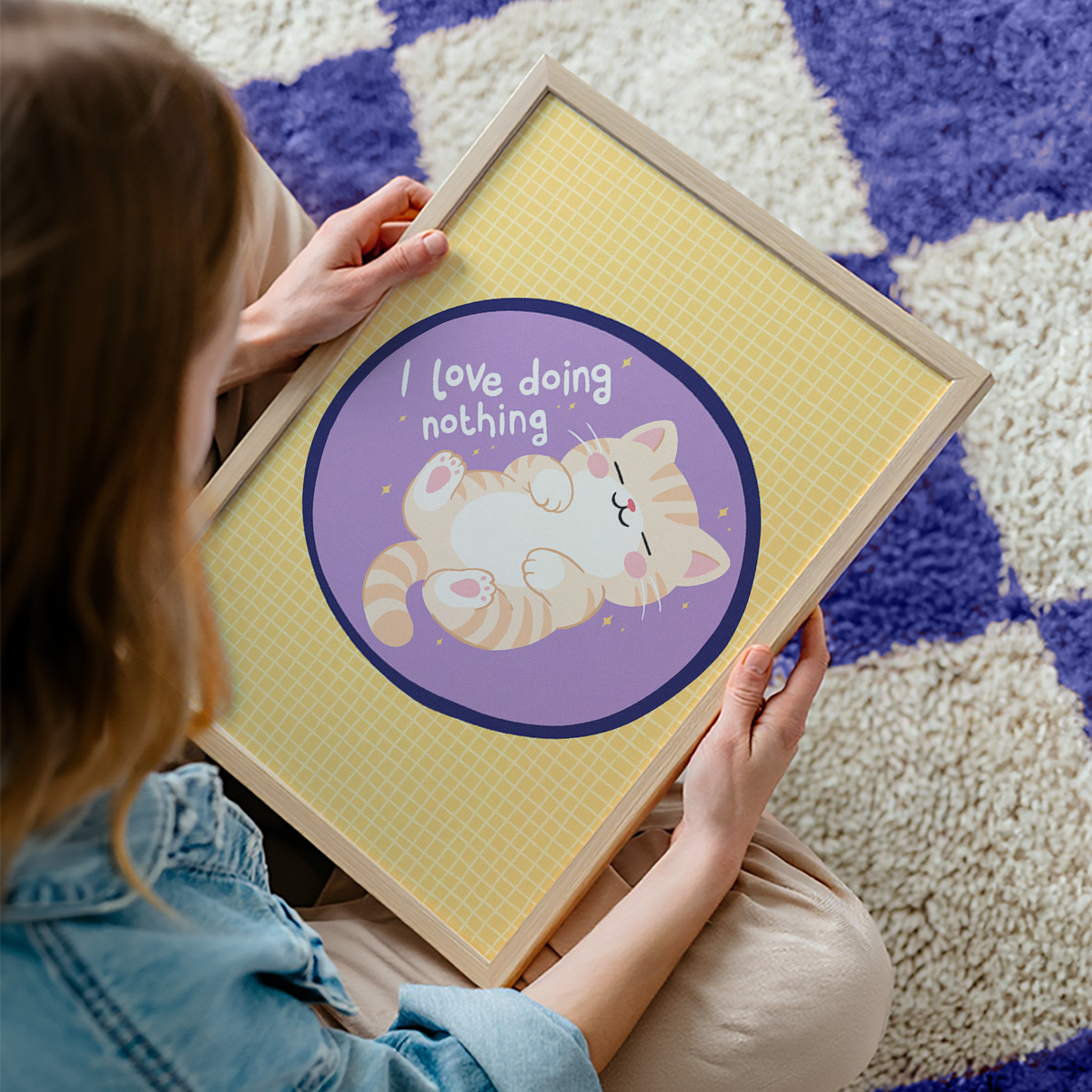 A yellow and purple print, with an illustration of a ginger cat laying on its back. Next to the cat is a quote that reads 'I love doing nothing'.