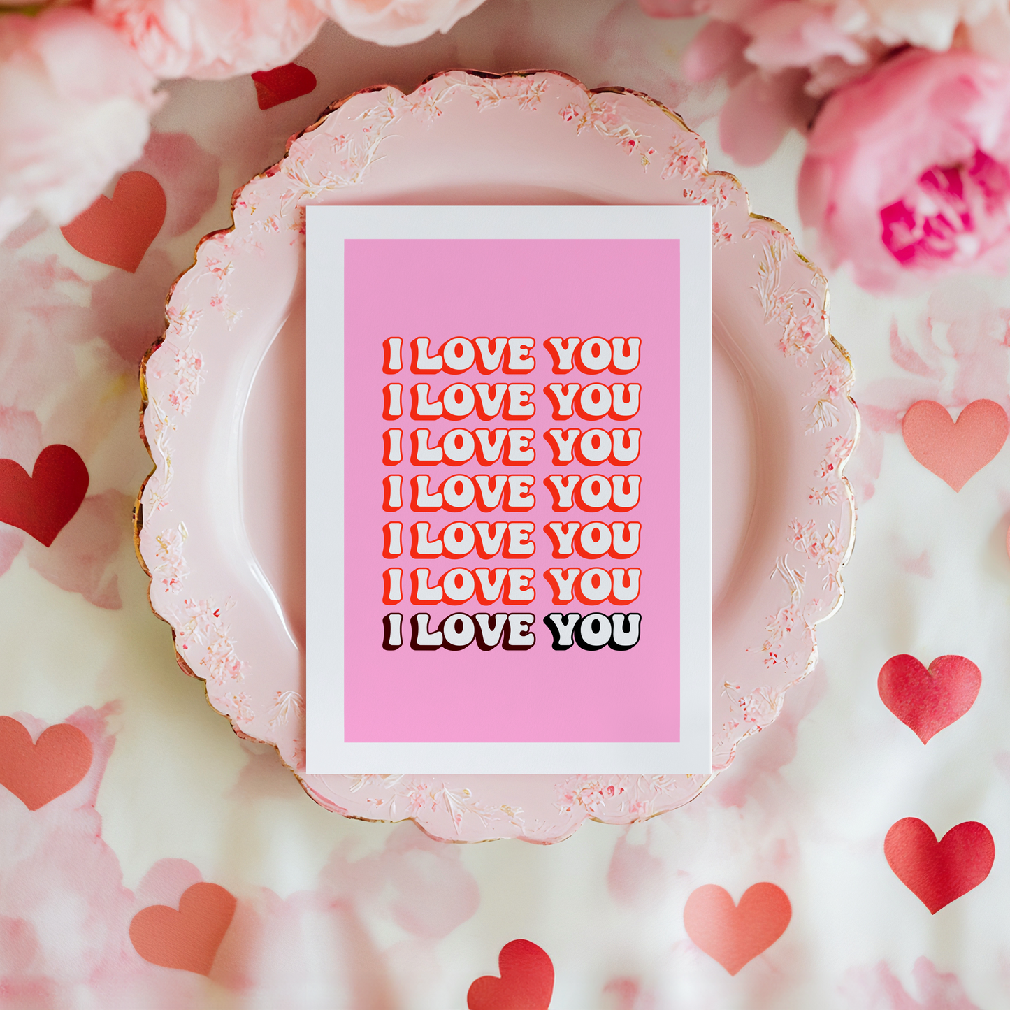 a pink card, with the words I love you, repeating across the front of the card.