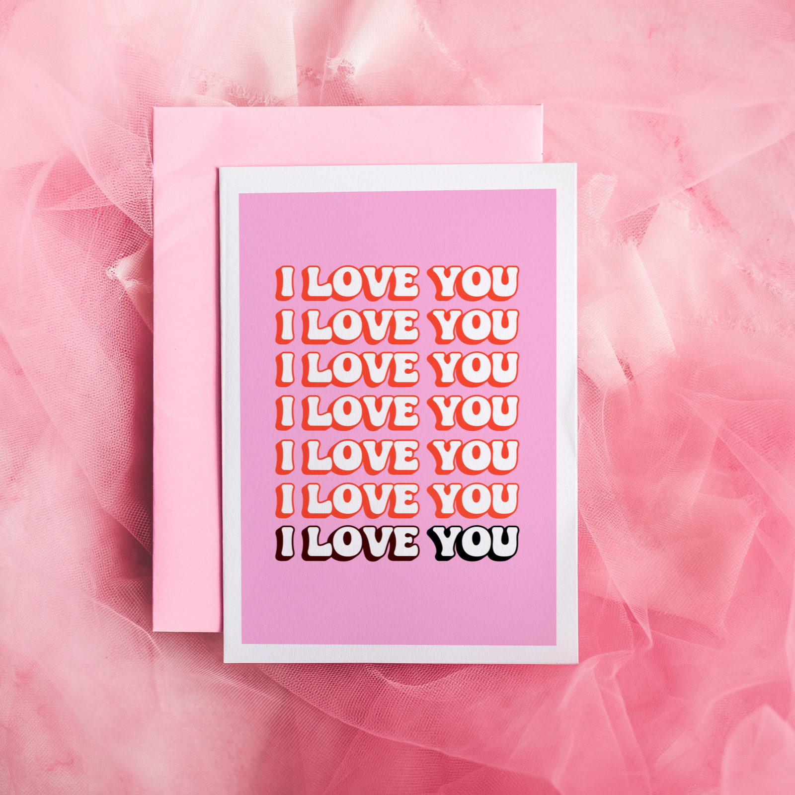 a pink card, with the words I love you, repeating across the front of the card.