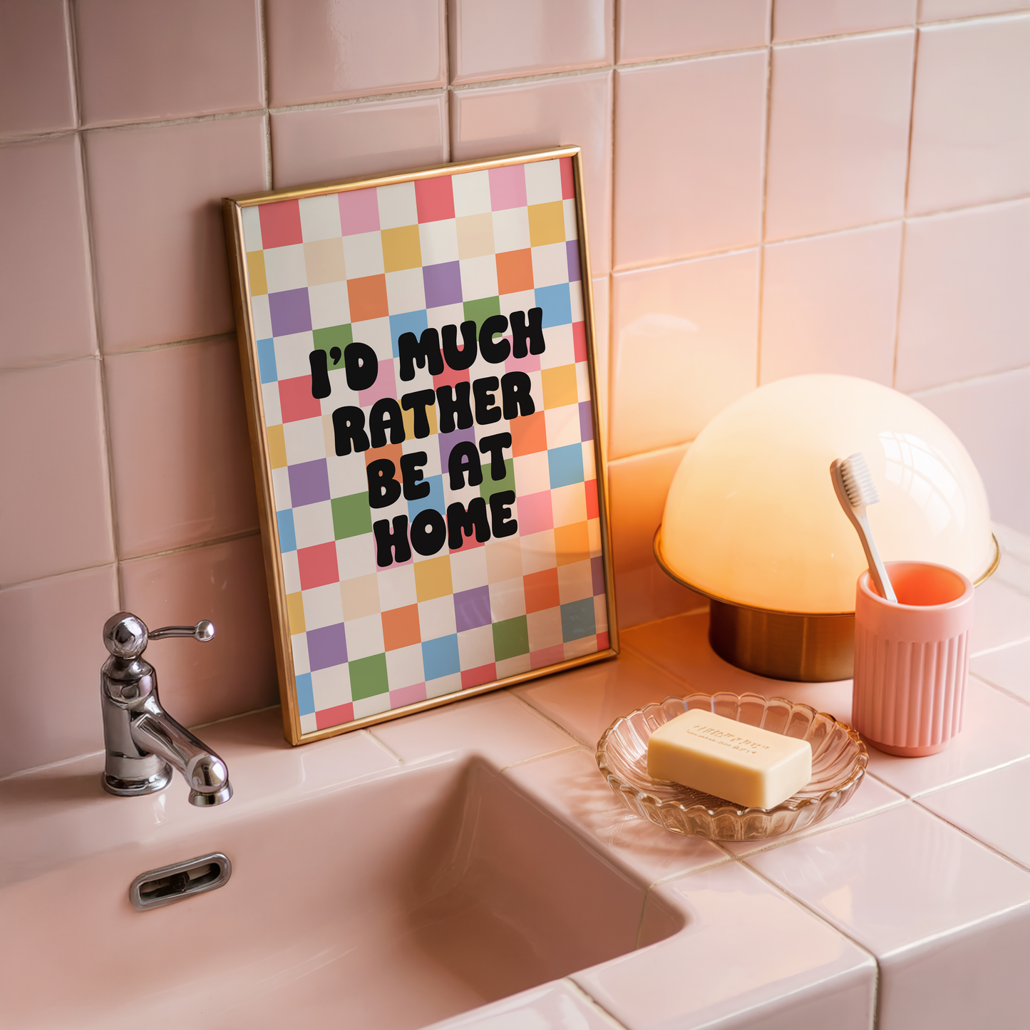 A colourful checkered print with the text 'I'd much rather be at home' centred, set against a white background.