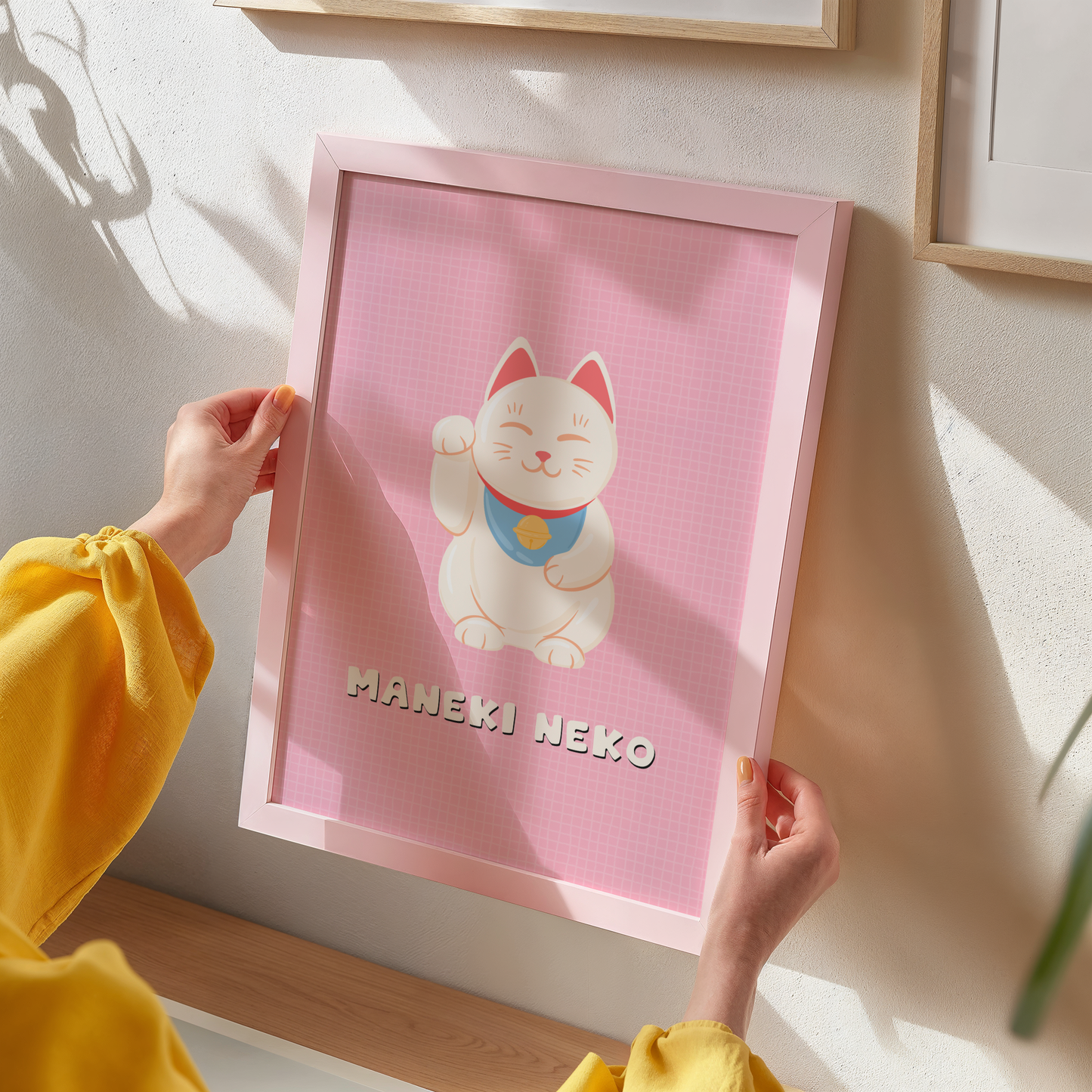 An art print featuring a cute cartoon Maneki-neko (lucky cat) on a pink background.
