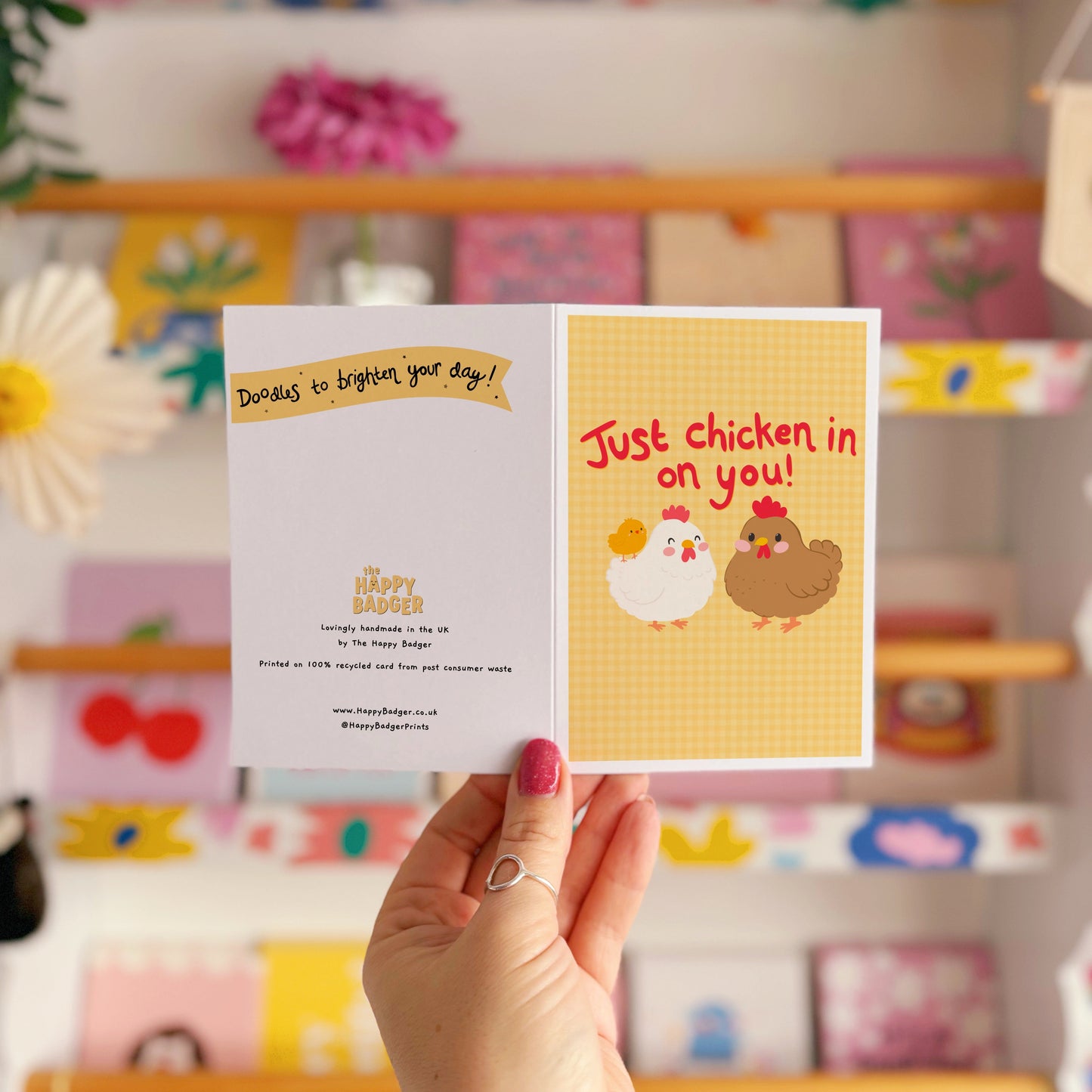 Card with chicken illustrations and red text that says 'Just chicken in on you!', with a yellow gingham background.