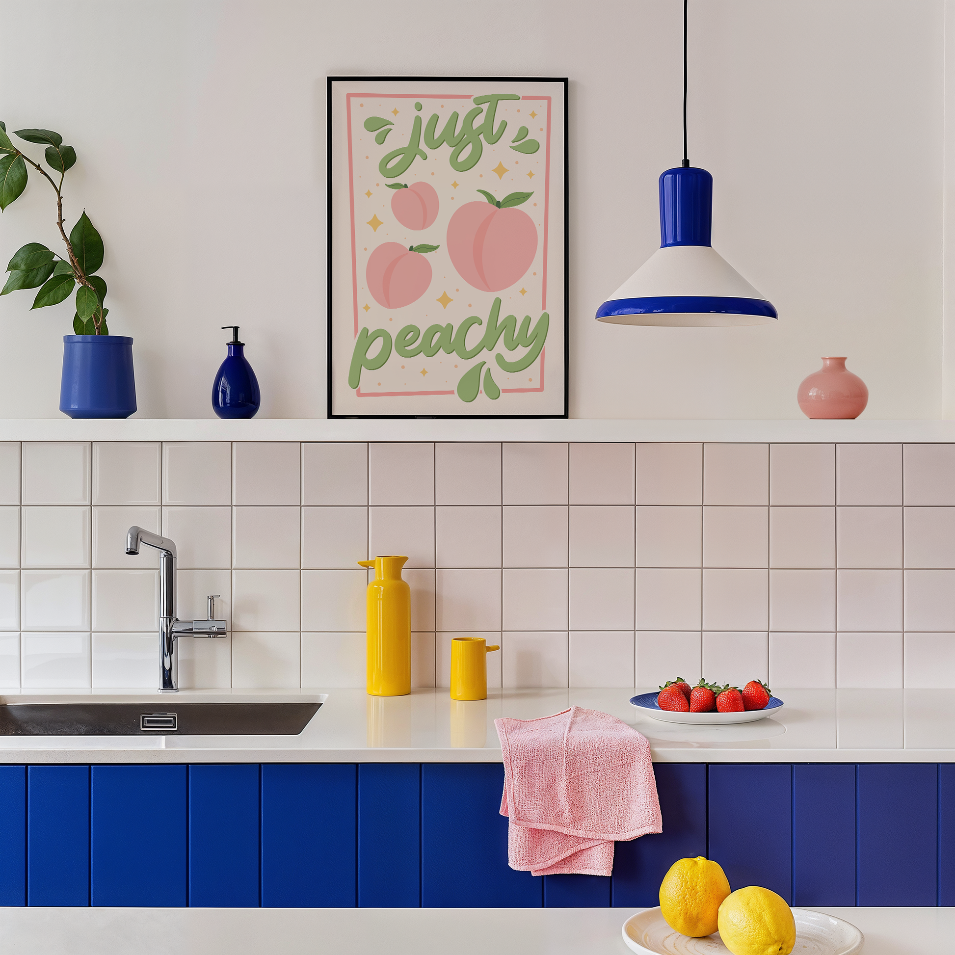 An art print with the text 'just peachy' hand-lettered in teal script, accompanied by illustrations of pink peaches and leaves, and a soft pink border.