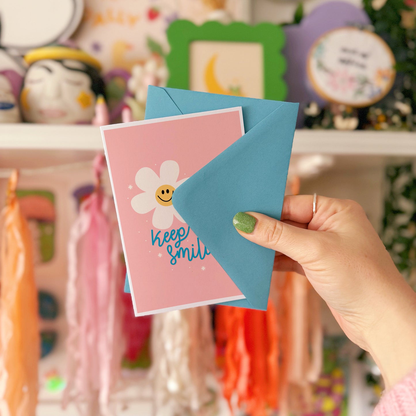 Card with smiley flowers and 'Keep smiling' text on a pink background