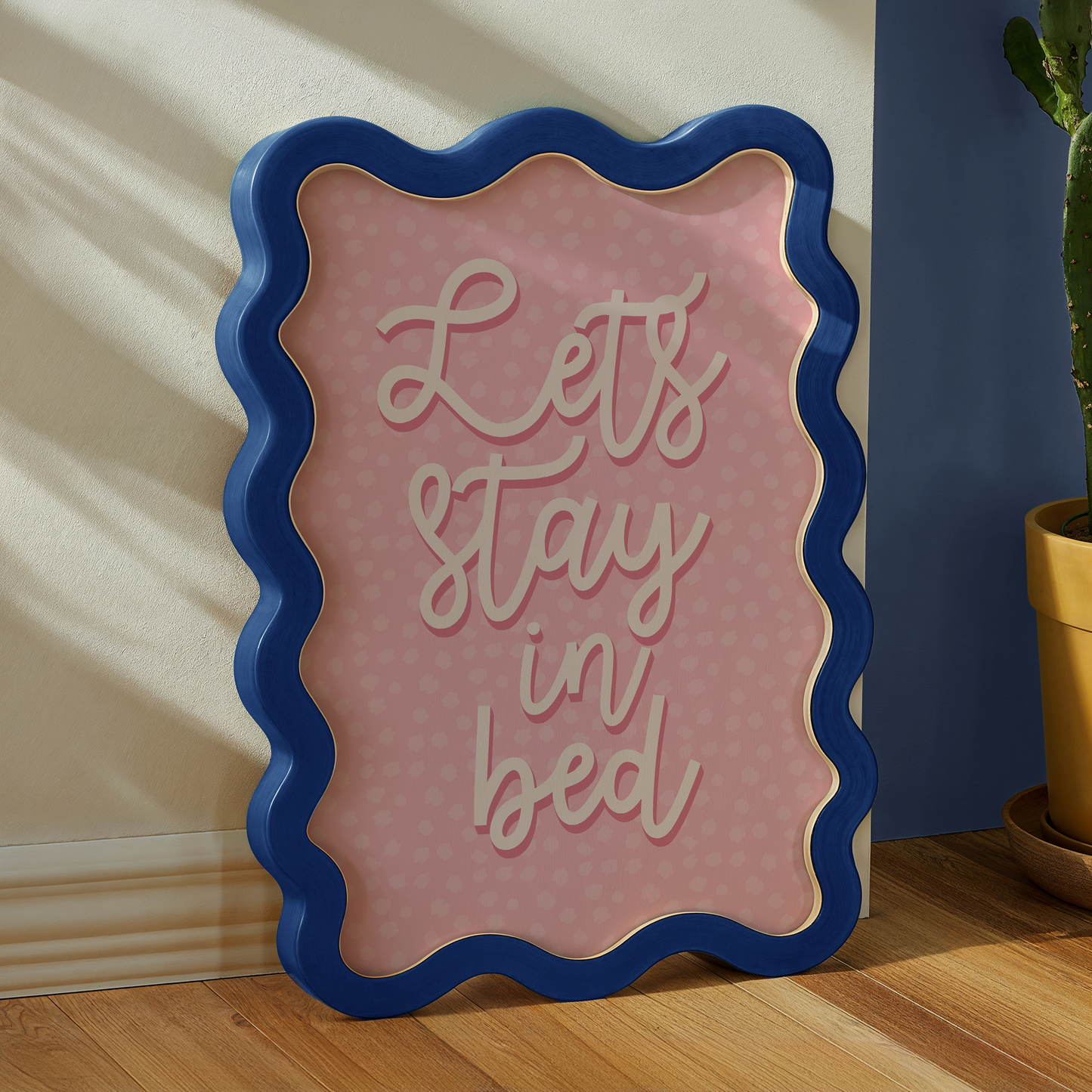 A cute print with a pink polka dot background and a quote saying, let's stay in bed.