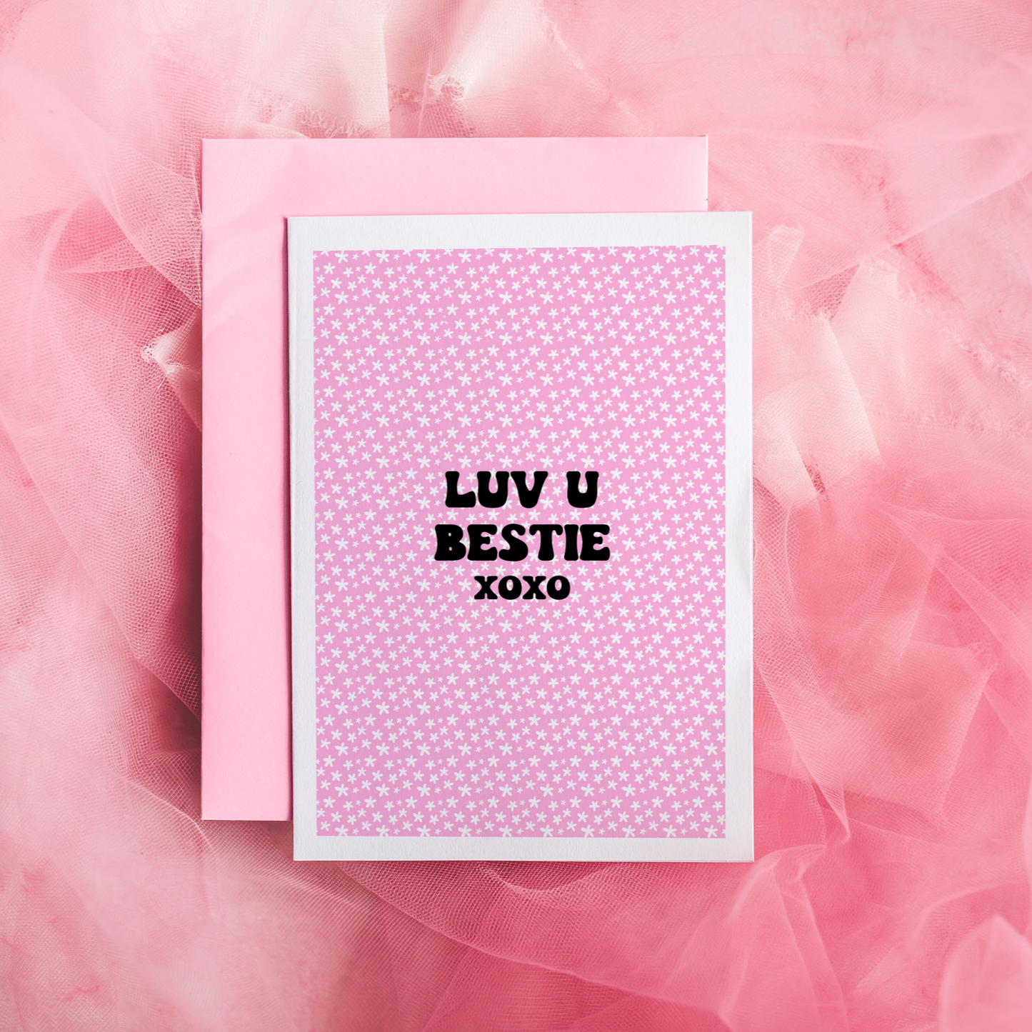 A pink greetings card, with the message 'Luv u bestie xoxo' on the front.