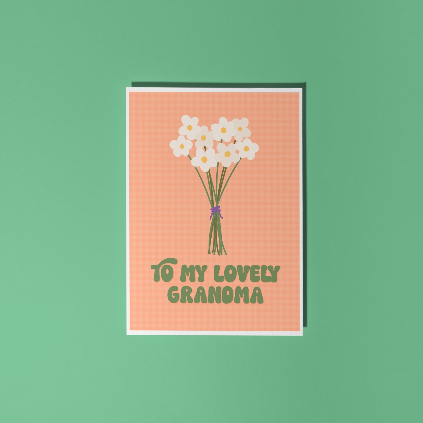 An orange greeting card with the words 'to my lovely Grandma' on the front, with a bunch of daisies.